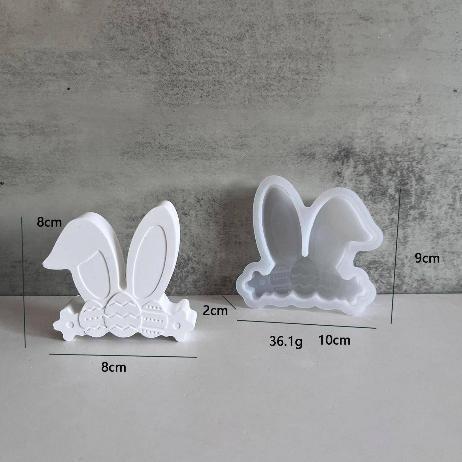 Zwei kleine weiße hasenförmige Formen oder Ornamente, von vorne und hinten gezeigt, mit beschrifteten Abmessungen 8 cm, 9 cm, 10 cm, 2 cm und Gewicht 36,1 g.