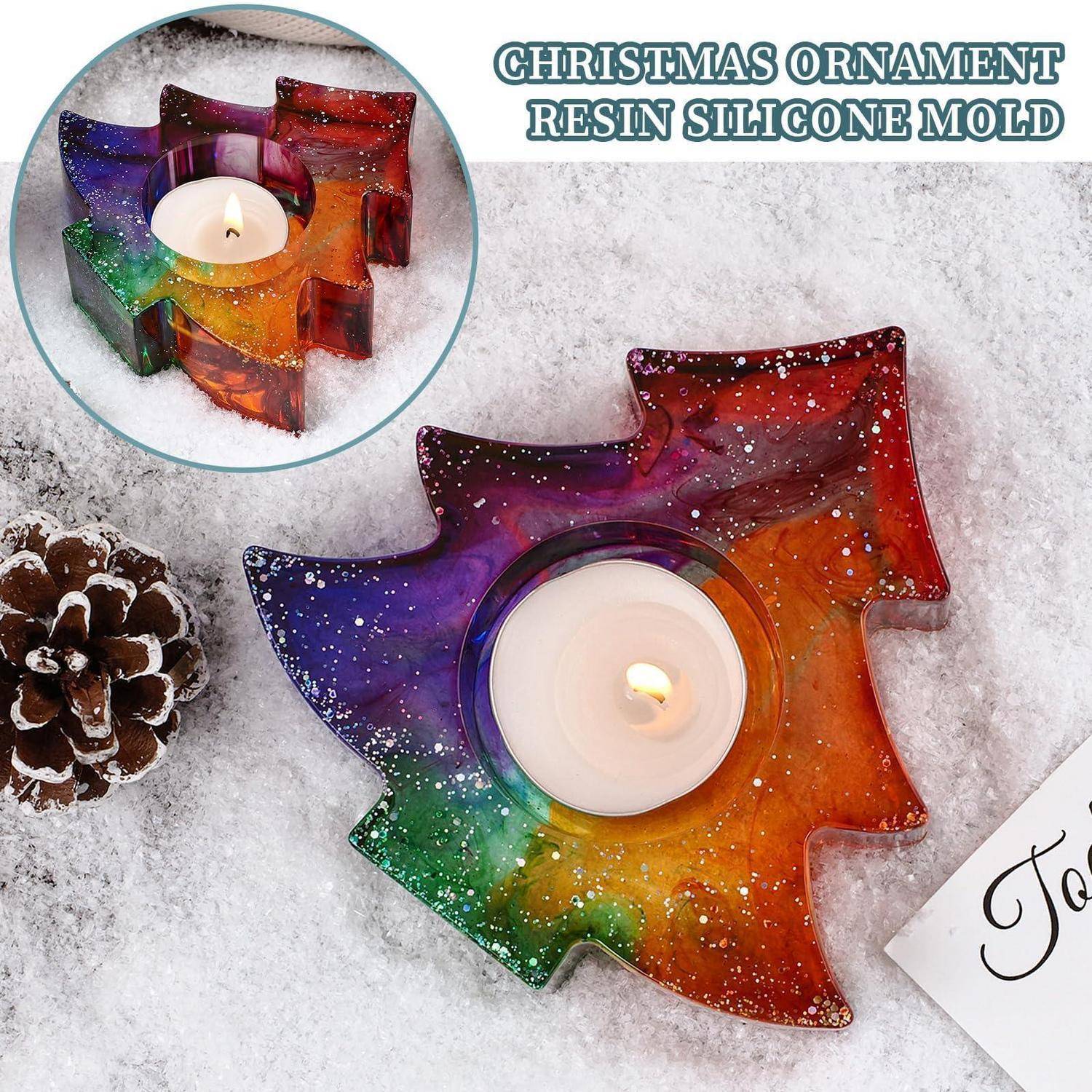 Regenbogenfarbene weihnachtsbaumförmige Harz-Silikonform mit einer brennenden Teelicht-Kerze auf einer schneebedeckten Oberfläche, mit Produkteinsatz und Text „WEIHNACHTSBAUMKUGEL-HARZ-SILIKONFORM