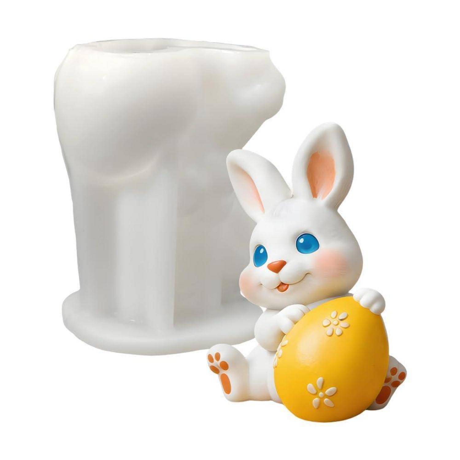 Weiße keramikstil-Kaninchenfigur, die ein gelbes Ei hält, in einer Pose vor einem weißen zahnförmigen Behälter oder Halter.