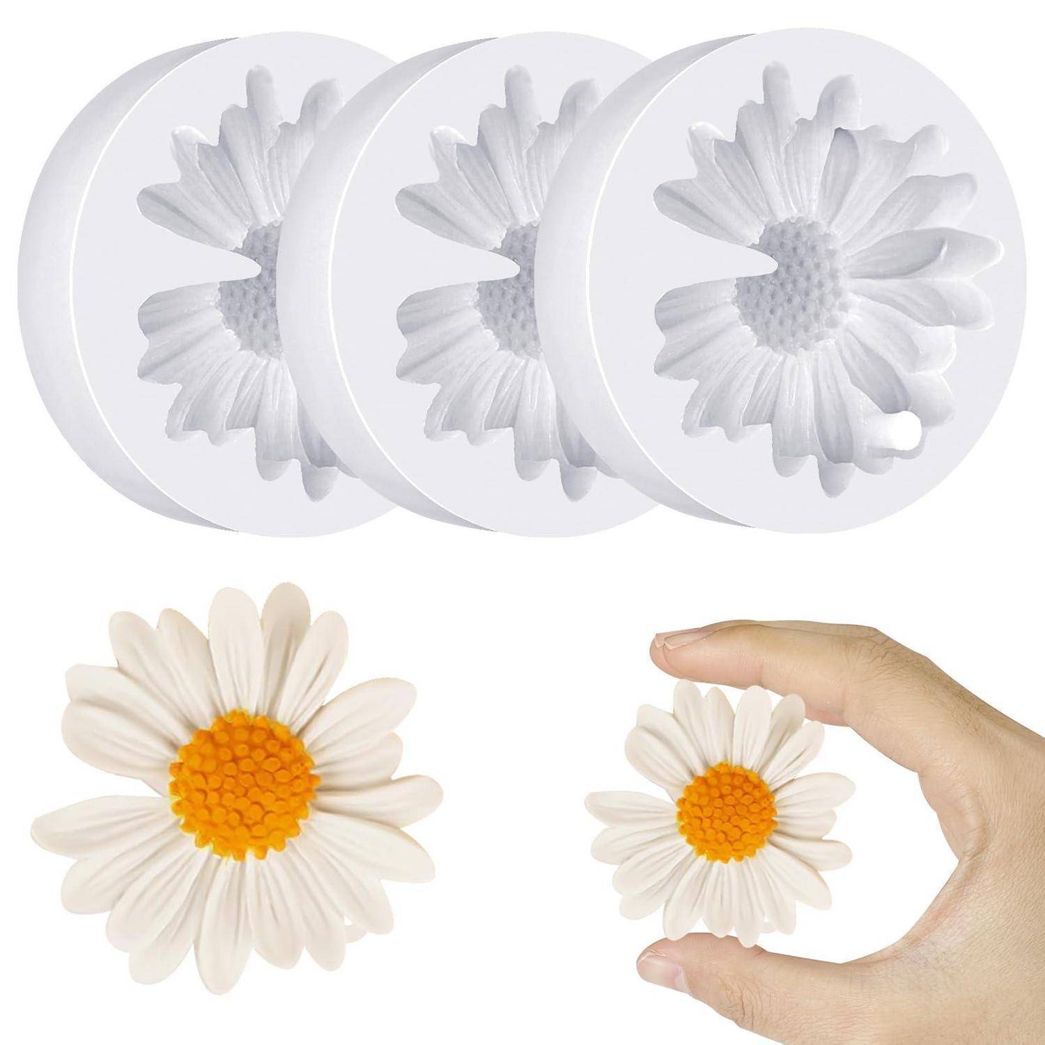 Weiße Gänseblümchenblüten-Silikonform mit drei kreisförmigen Silikonformen oben abgebildet; unten wird ein kleines fertiges Gänseblümchen mit einer Hand verglichen, um die Größe zu zeigen.