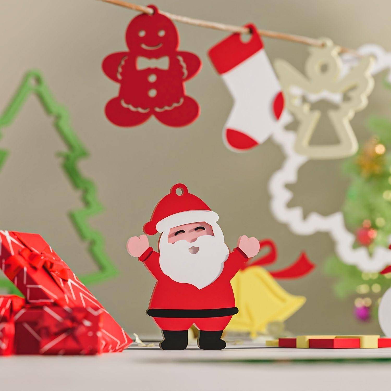 Kleine Weihnachtsmannfigur mit erhobenen Armen, stehend zwischen hängenden Weihnachtsdekorationen, einem eingepackten Geschenk und Glocken auf einer festlichen Weihnachtsdisplay.