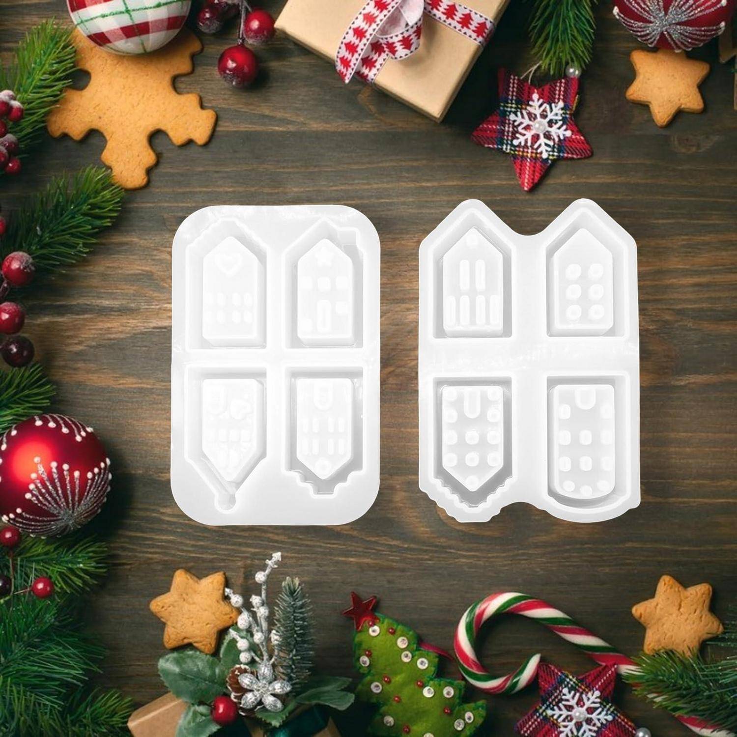 Zwei weiße Weihnachtskugel-Formen auf einem Holztisch, umgeben von Weihnachtsdekoration wie Tannenzweigen, Keksen, Geschenken und roten Kugeln.