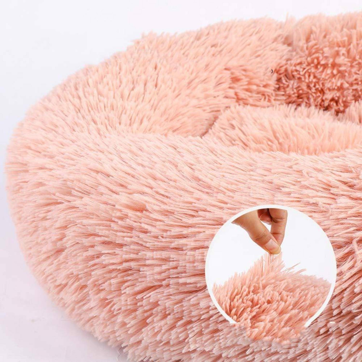 Nahaufnahme eines weichen rosa zottigen Kunstfellstoffs mit einer Hand, die die langen flauschigen Fasern anzieht, um die Textur zu zeigen.