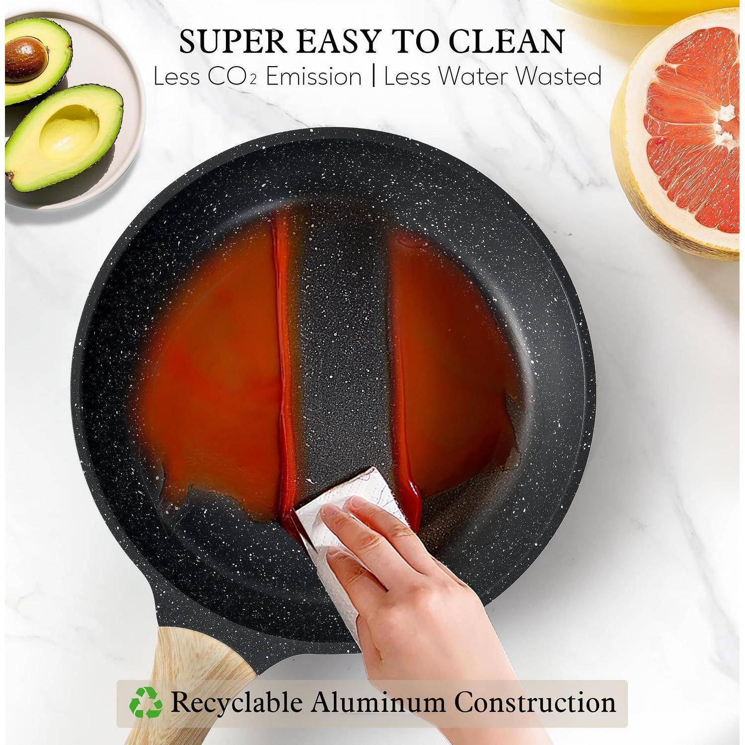 Handwäsche einer gesprenkelten Antihaftpfanne mit einem Schwamm; Text besagt „SUPER LEICHT ZU REINIGEN", „Weniger CO2-Emissionen | Weniger Wasserverschwendung"" und „Recycelbares Aluminium-Design"".