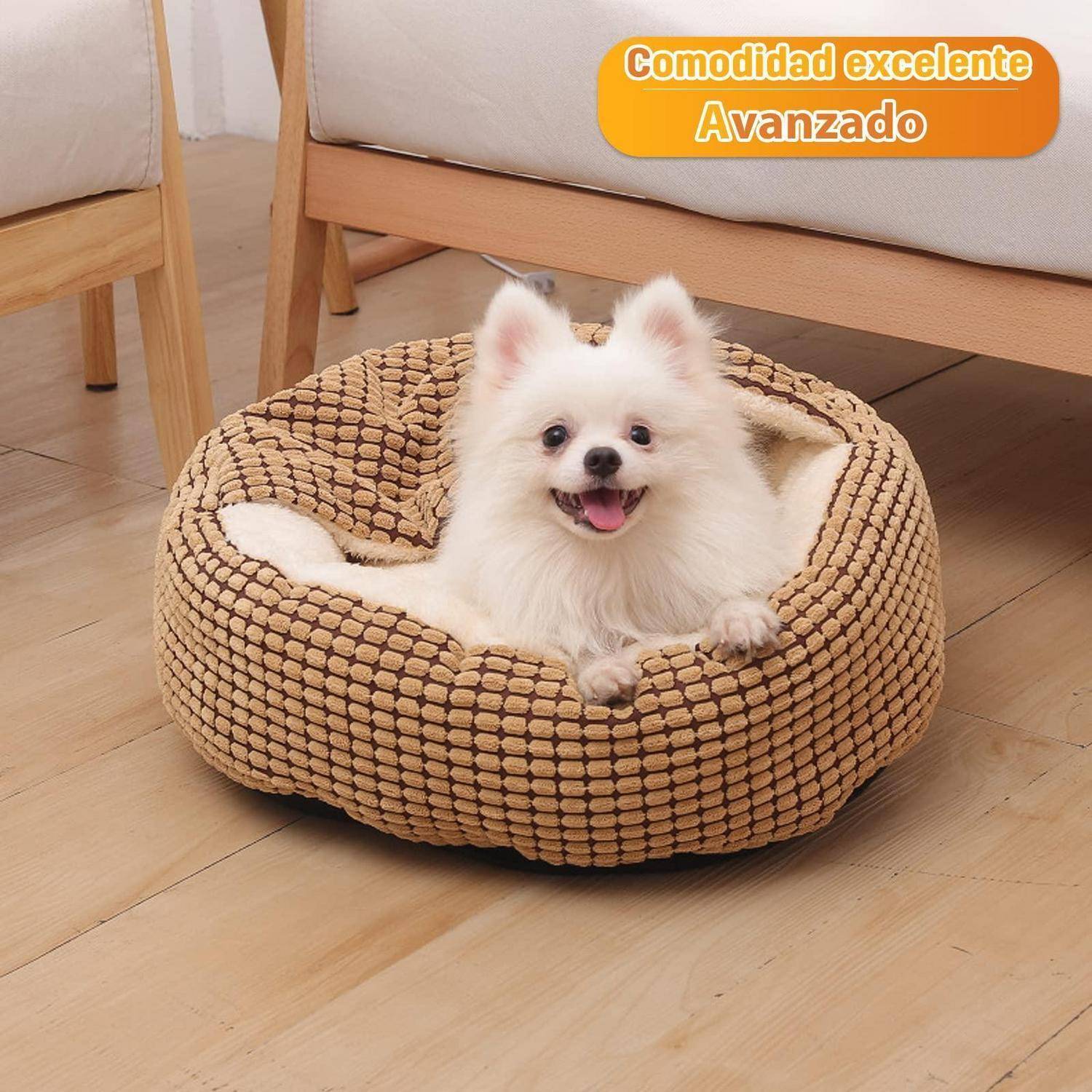 Kleiner weißer flauschiger Hund sitzt in einem gewebten beigen Haustierbett auf einem Holzboden, mit spanischem Text „Comodidad excelente Avanzado" in der Ecke.