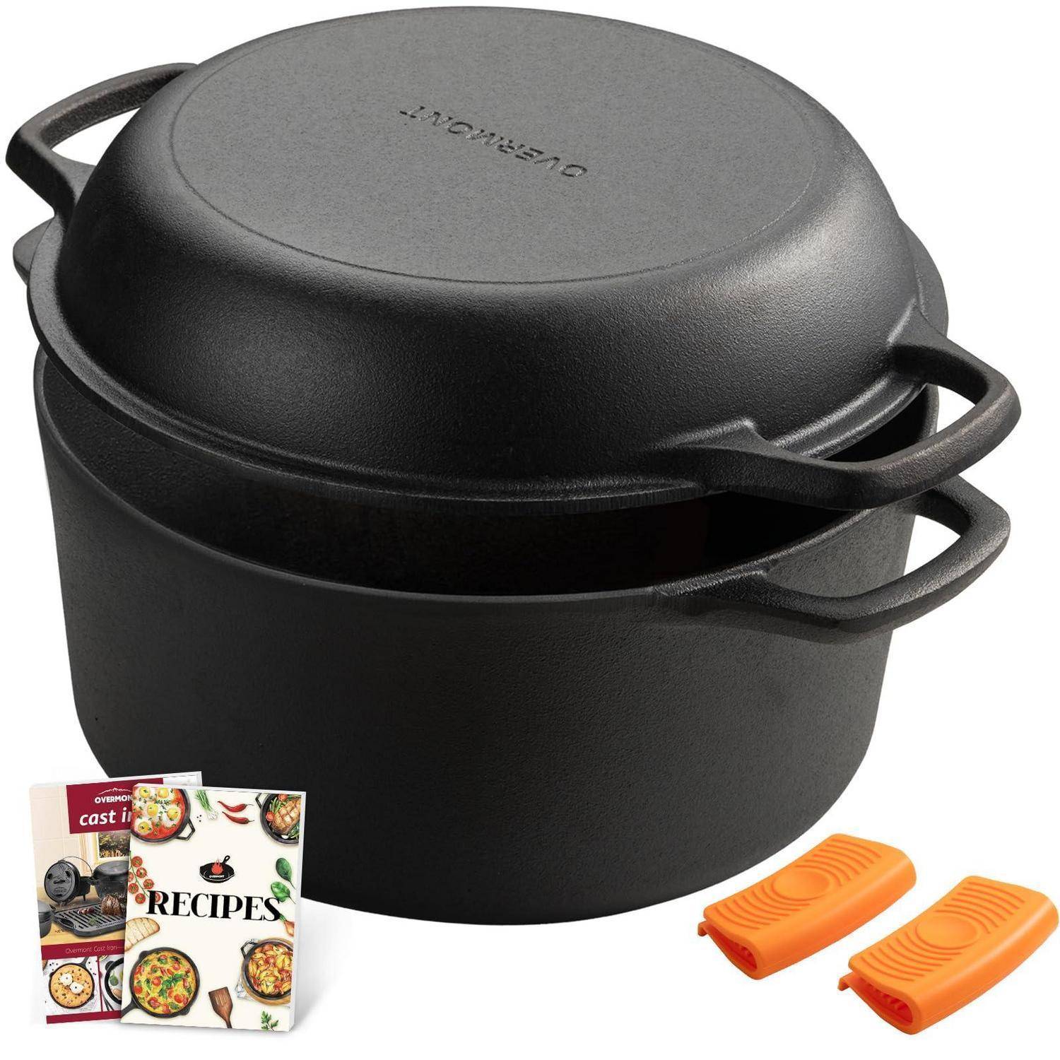 Schwarzer Gusseisen-Bräter mit Deckel, Rezepthefte und zwei orangefarbene Silikongriffschoner auf weißem Hintergrund.