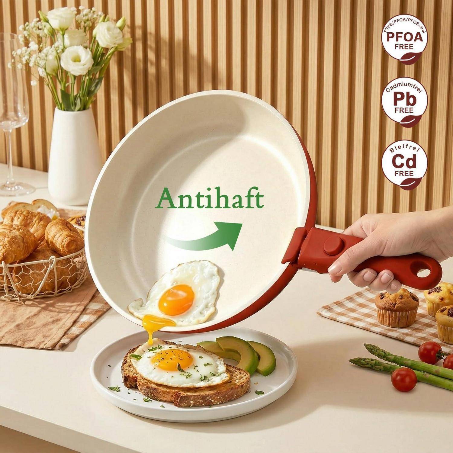 Antihaft-Bratpfanne mit „Antihaf"-Schriftzug und Pfeilgrafik, auf der ein Spiegelei auf einen Frühstücksteller gleitet; Abzeichen bescheinigen PFOA-, Pb- und Cd-Freiheit.