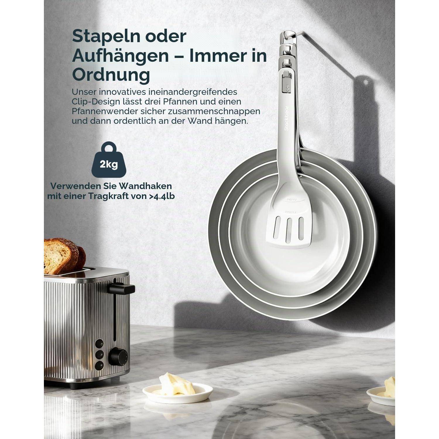 Deutsches Inserat zeigt stapelbare Hänge-Clip-Design-Pfannen und einen Pfannendeckel an einem Wandhaken, mit 2 kg Traglastfähigkeit und Text „Stapeln oder Aufhängen – Immer in Ordnung"