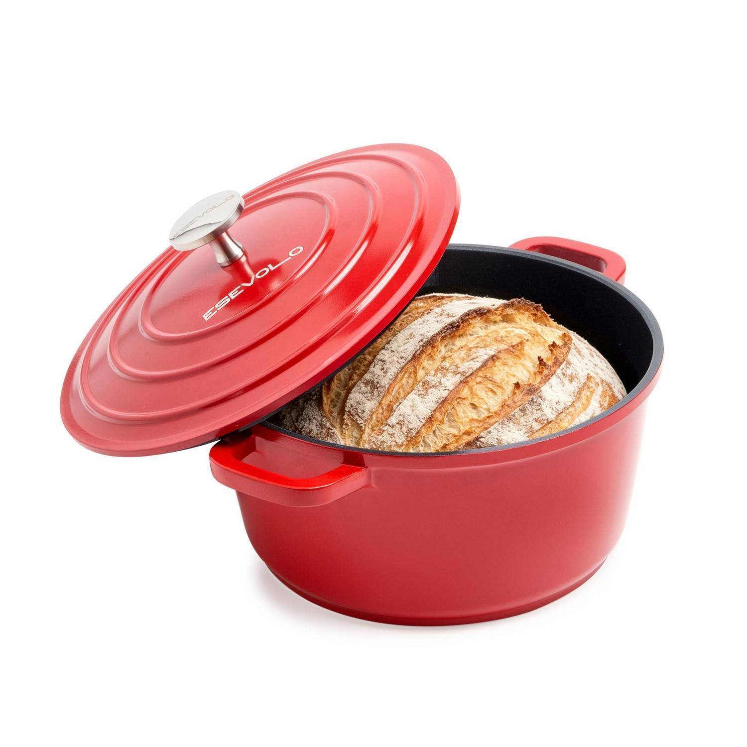 Roter Bräter mit leicht geöffnetem Deckel, aus dem ein rundes Brot mit knuspriger Kruste sichtbar ist.