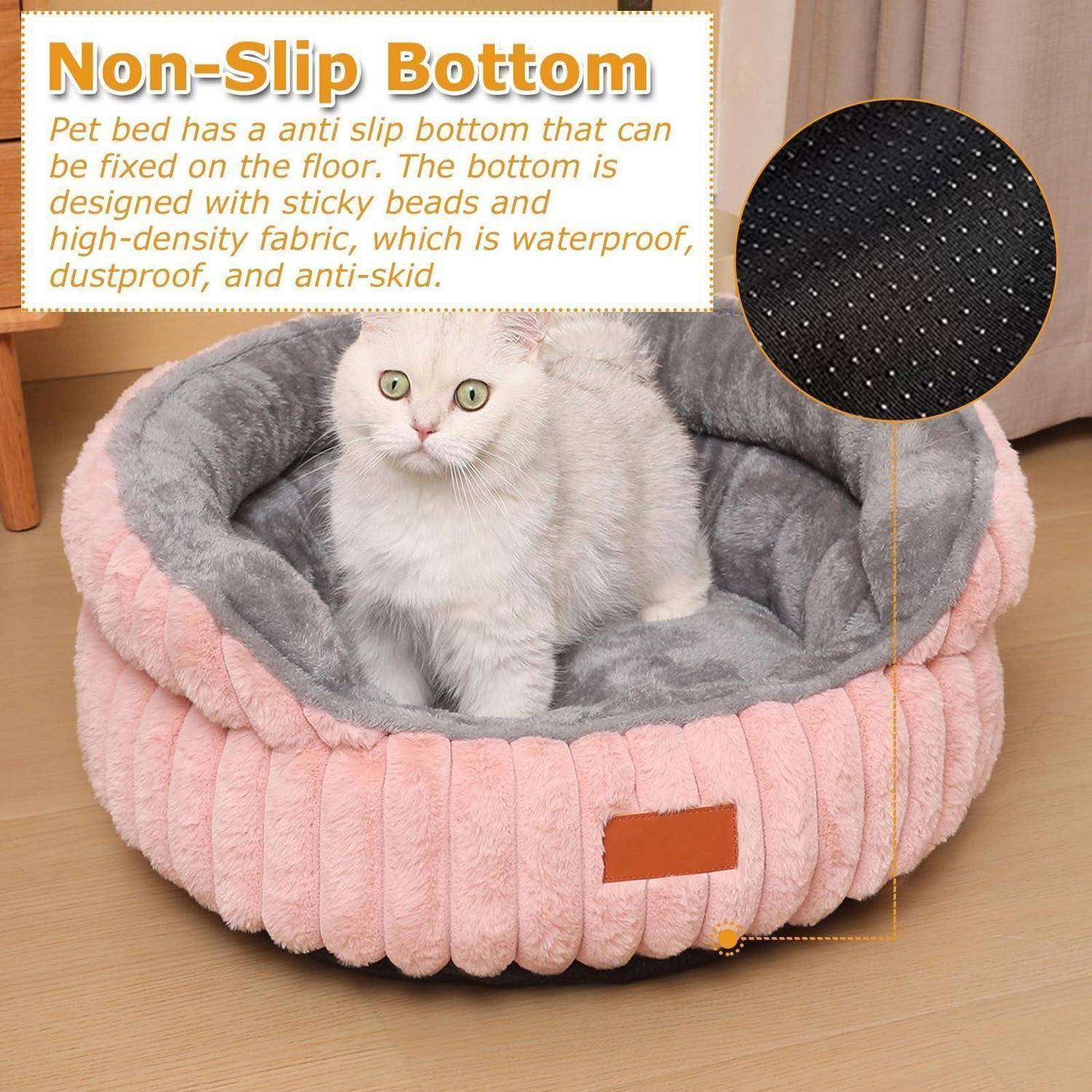 Weiße Katze, die in einem rosa und grauen flauschigen Haustierbett sitzt, mit einer Vergrößerung, die den rutschfesten Boden zeigt, und Text, der wasserundurchlässigen, staubdichten, rutschfesten Stoff bewirbt.