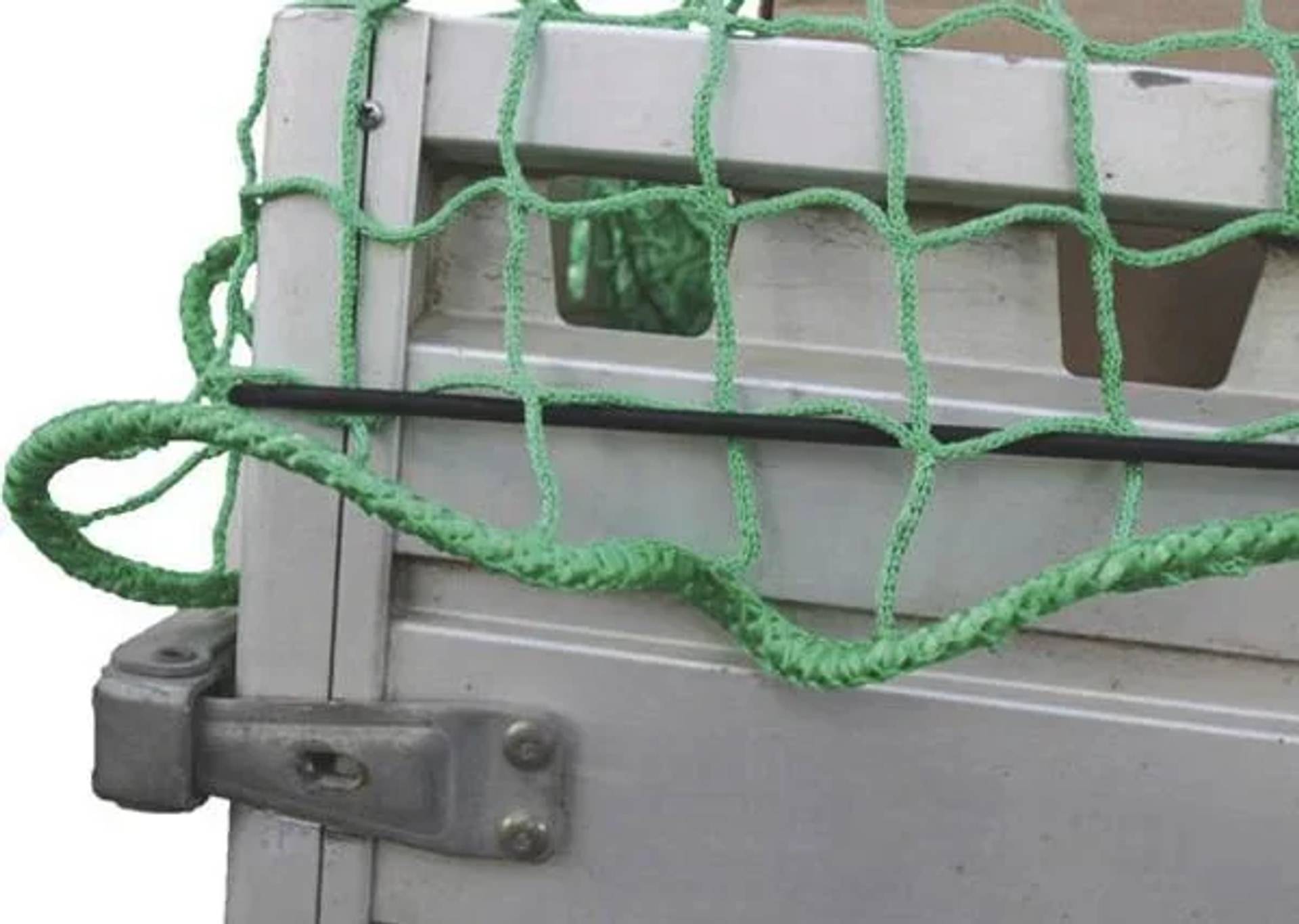 Nahaufnahme eines Metall-Frachtgitters oder einer Lastwagenttür, die mit einem grünen Seiltüll über einem rechteckigen Panel gesichert ist.