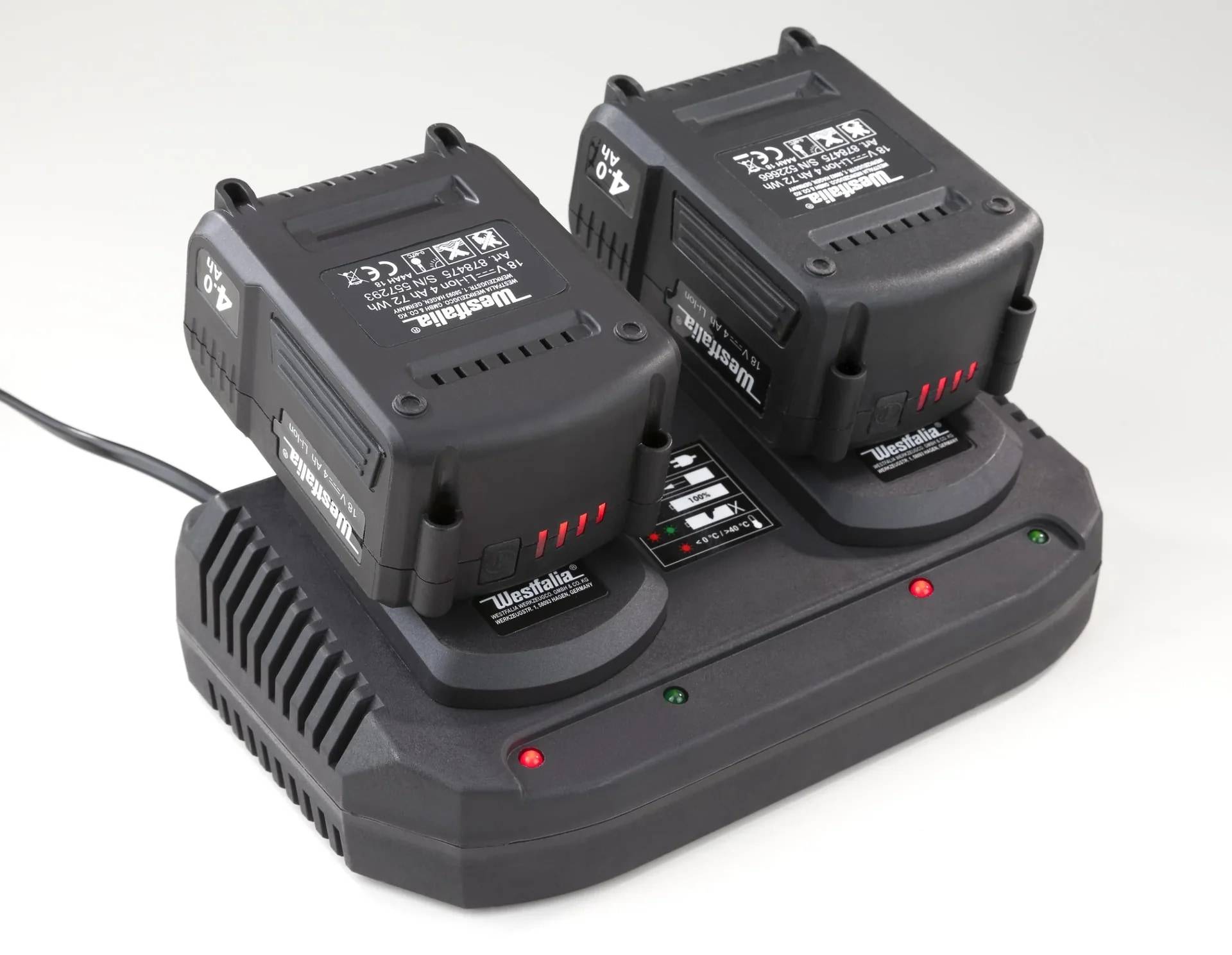 Doppelbatterie-Ladegerät mit zwei schwarzen schnurlosen Werkzeugbatterien, die auf einer Westfalia-Ladestation angedockt sind, mit roten und grünen Statusanzeigen.