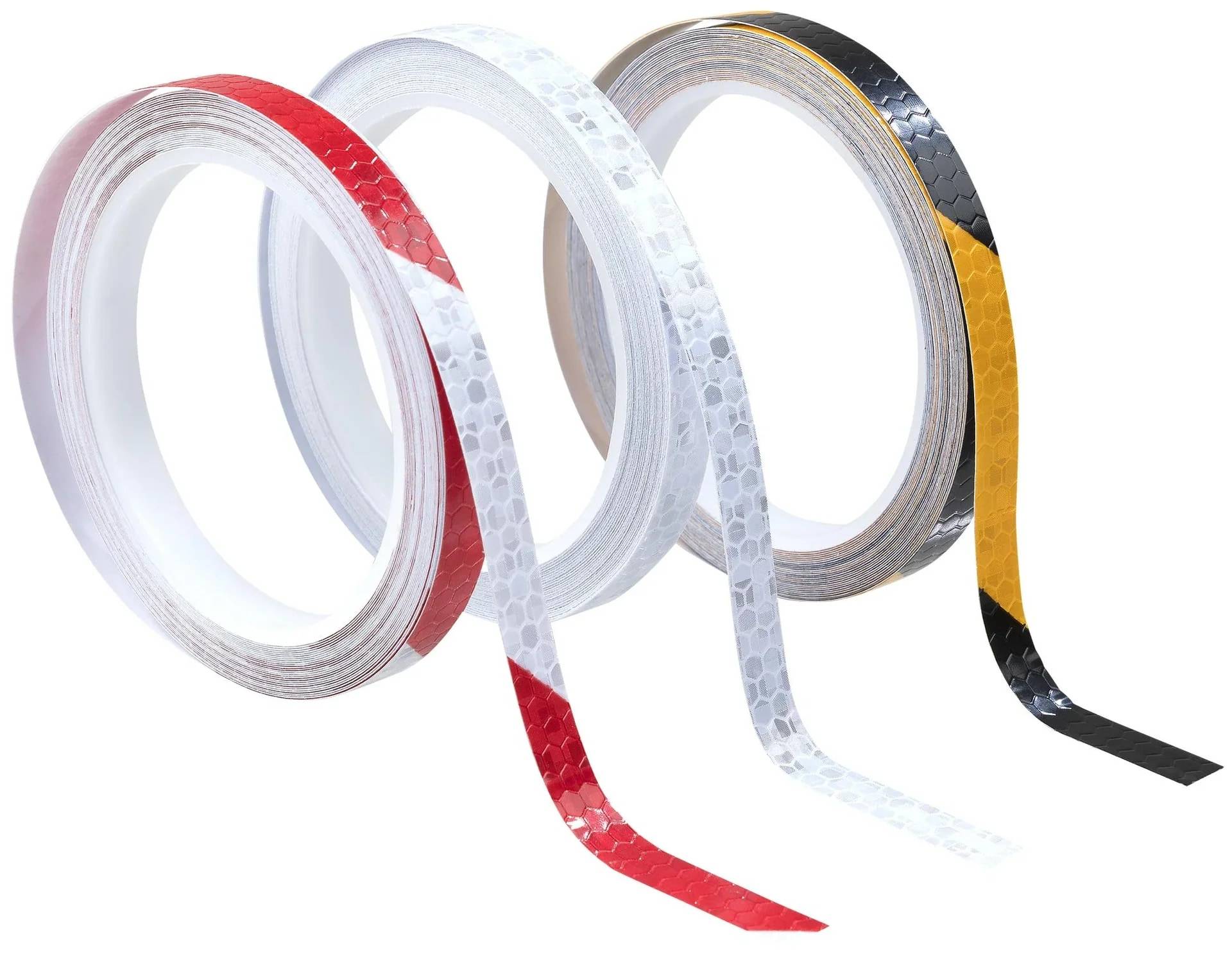 Drei Rollen reflektierendes Klebeband in Rot, Weiß und Gelb-Schwarz, mit abgewickelten Streifen, die nach unten hängen, auf weißem Hintergrund.