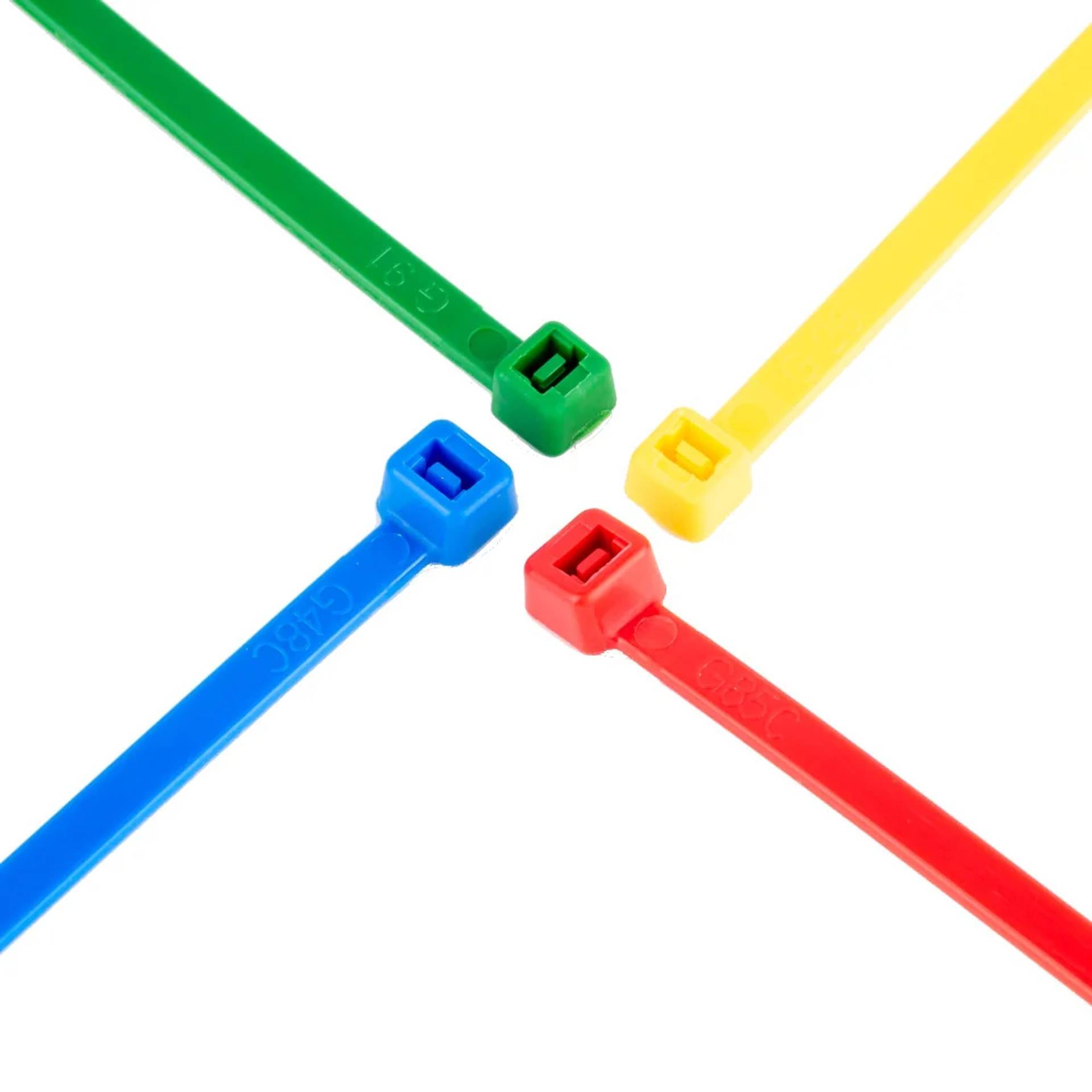 Vier farbige Kunststoffkabelbinder – grün, gelb, blau und rot – in einer Kreuzform auf weißem Hintergrund angeordnet.