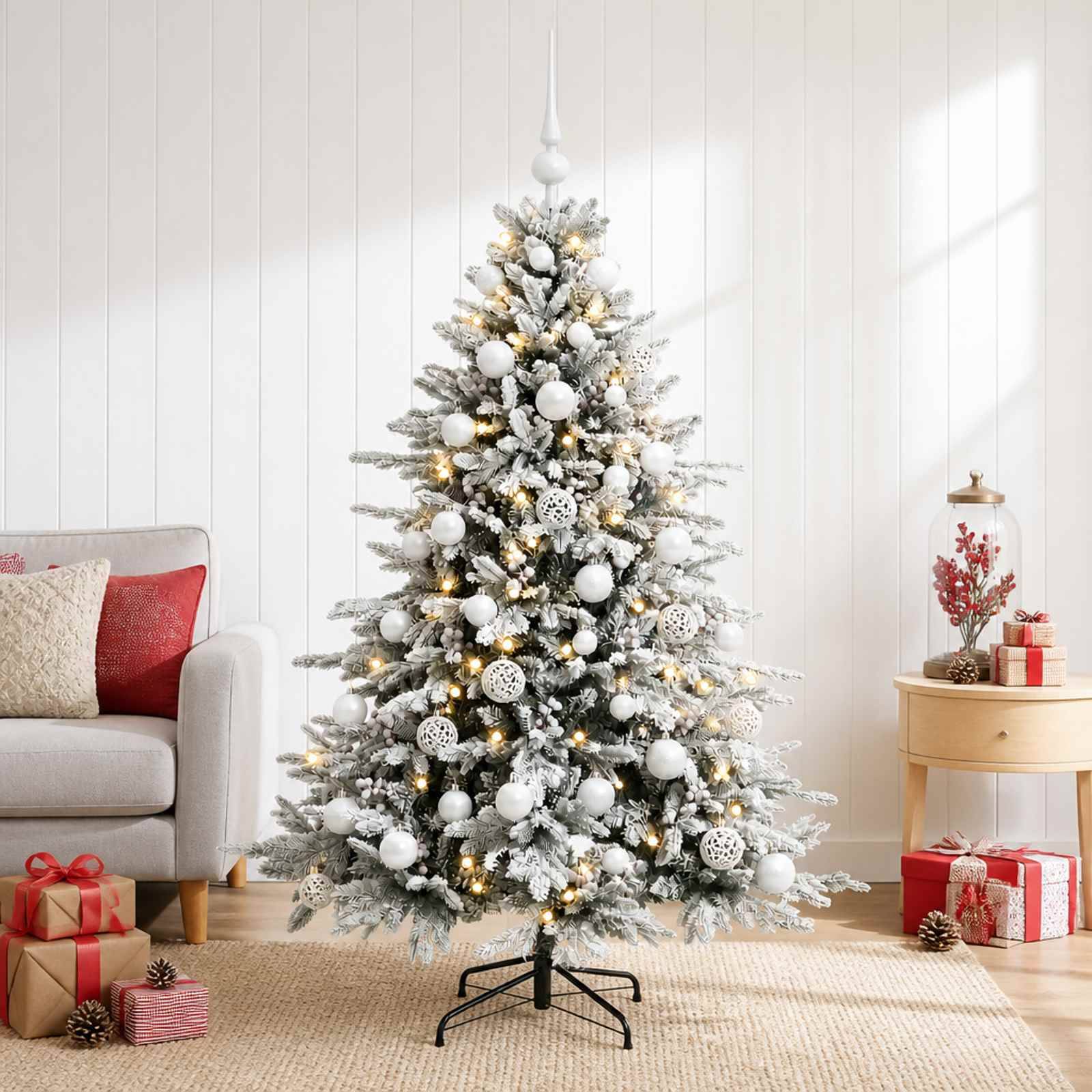 Geschmückter schneebedeckter Weihnachtsbaum mit weißen Kugeln und warmem Licht in einem hellen Wohnzimmer, umgeben von eingepackten Geschenken.