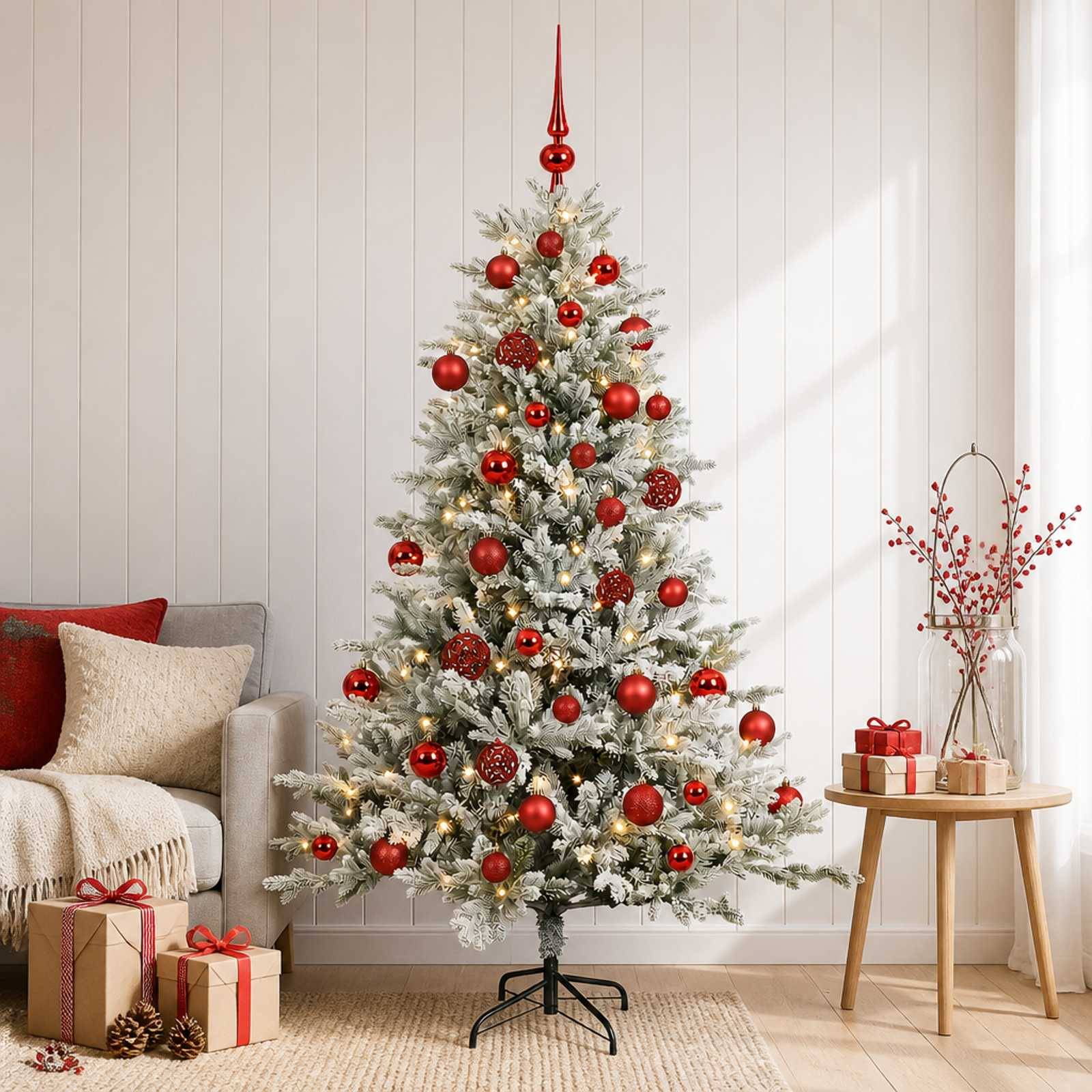 Ein geschmückter Weihnachtsbaum mit roten Ornamenten und Lichtern in einem Wohnzimmer, mit eingepackten Geschenken, einem Sofa und einem kleinen Beistelltisch mit Präsenten.