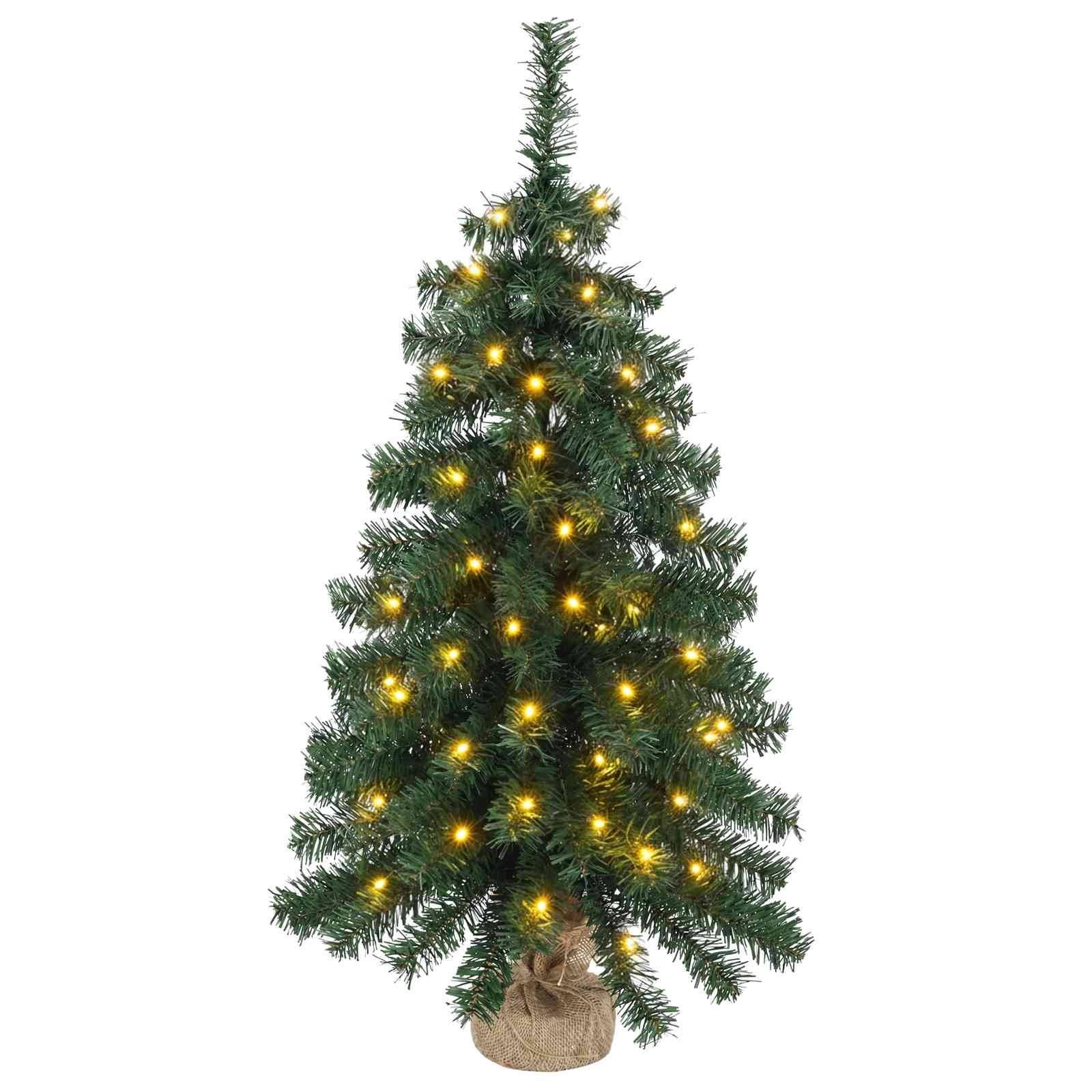 Kleiner künstlicher Weihnachtsbaum mit warmgelben Lichtern und mit Jute umwickeltem Sockel auf weißem Hintergrund.