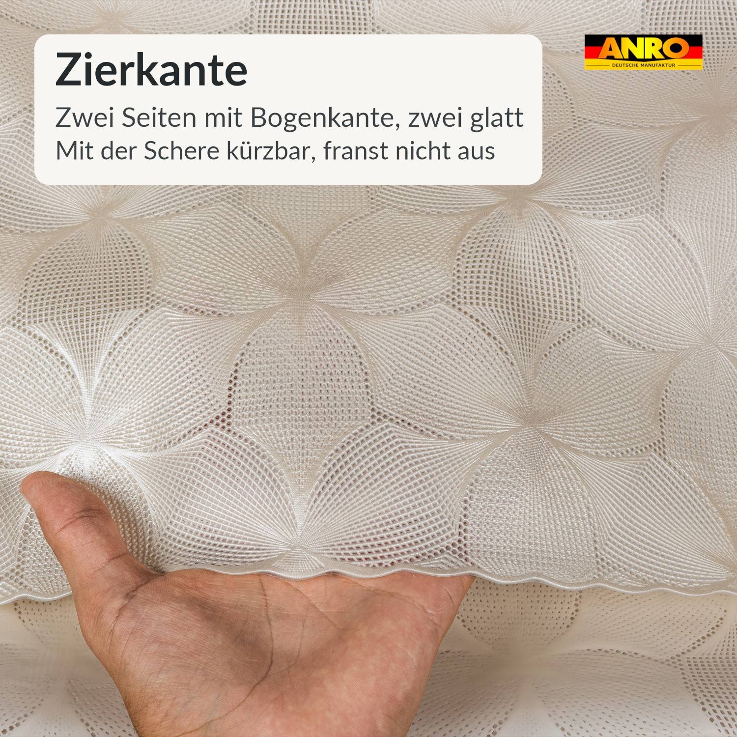 Hände halten eine strukturierte weiße Stoffprobe mit Muschelkantenkante; deutscher Text liest sich „Zierkante", „Zwei Seiten mit Bogenkante, zwei glatt"" und „Mit der Schere kürzbar, franst nicht aus"".