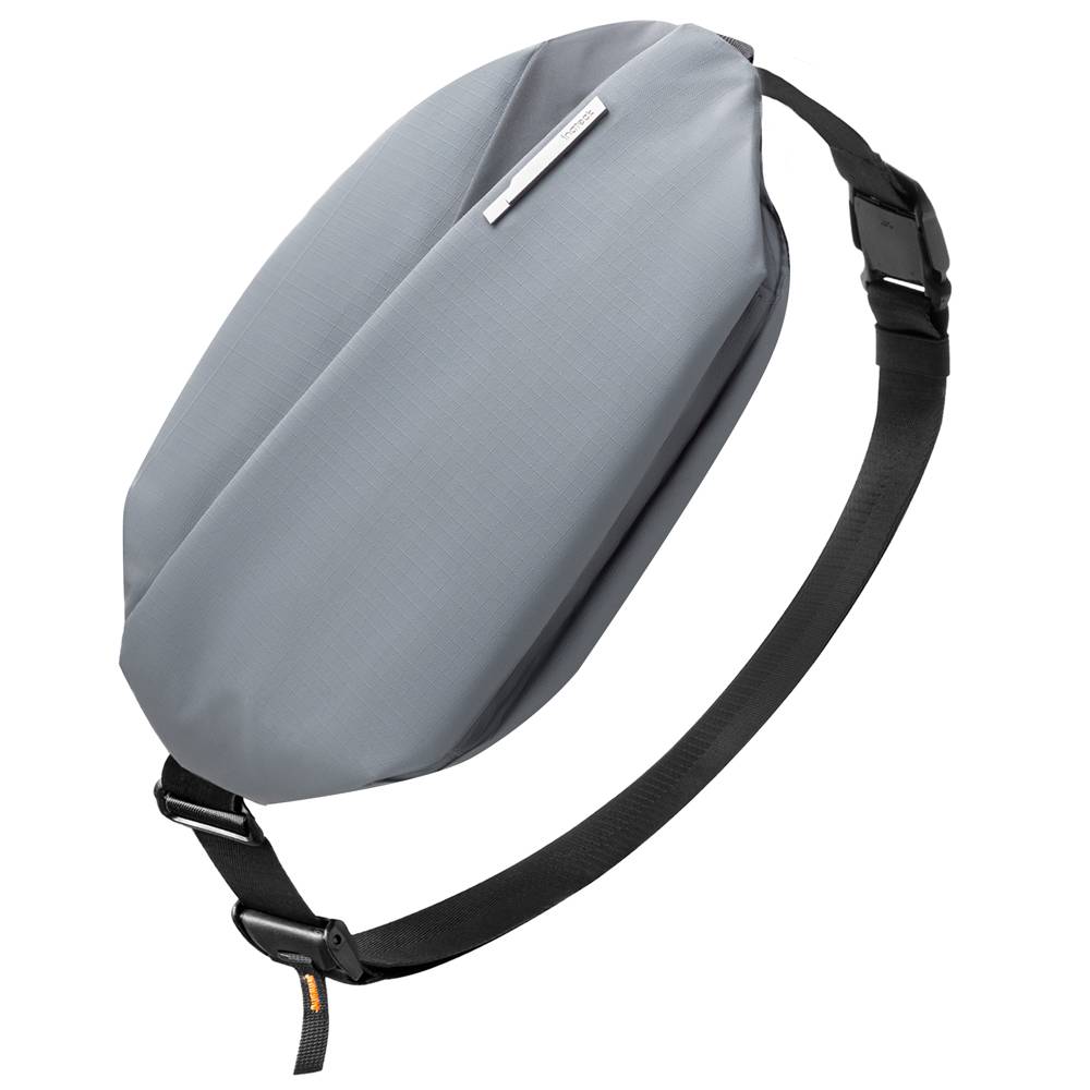 Graue Umhängetasche im Sling-Stil mit schwarzem verstellbarem Riemen, auf einfachem weißem Hintergrund dargestellt.