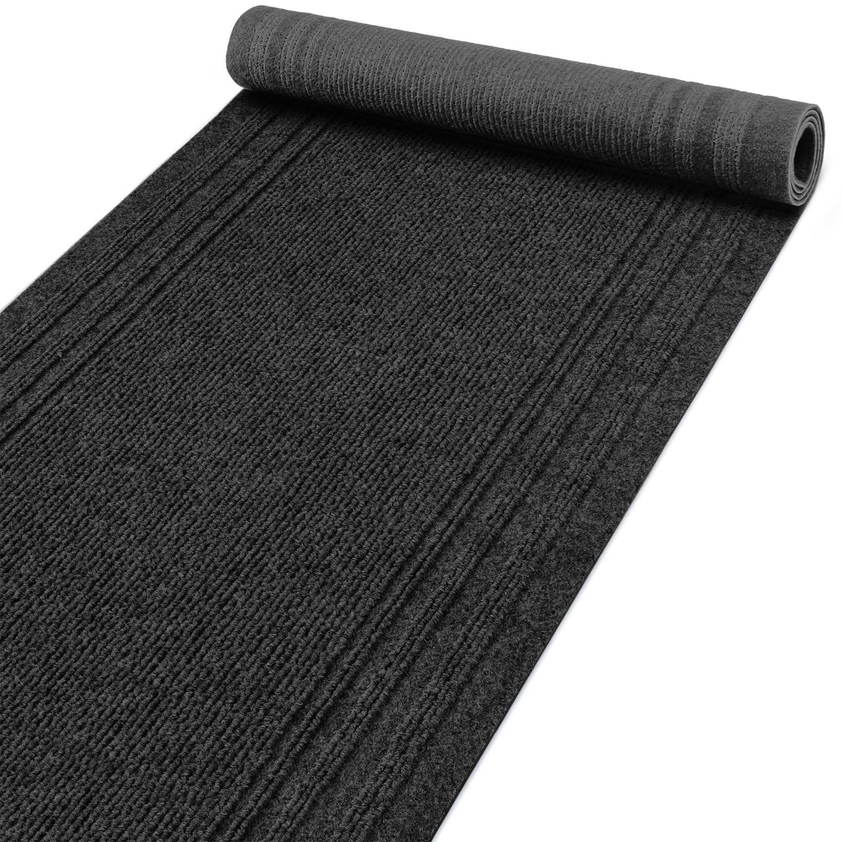 Gerollte schwarze strukturierte Bodenmatte oder Läufer auf weißem Hintergrund
