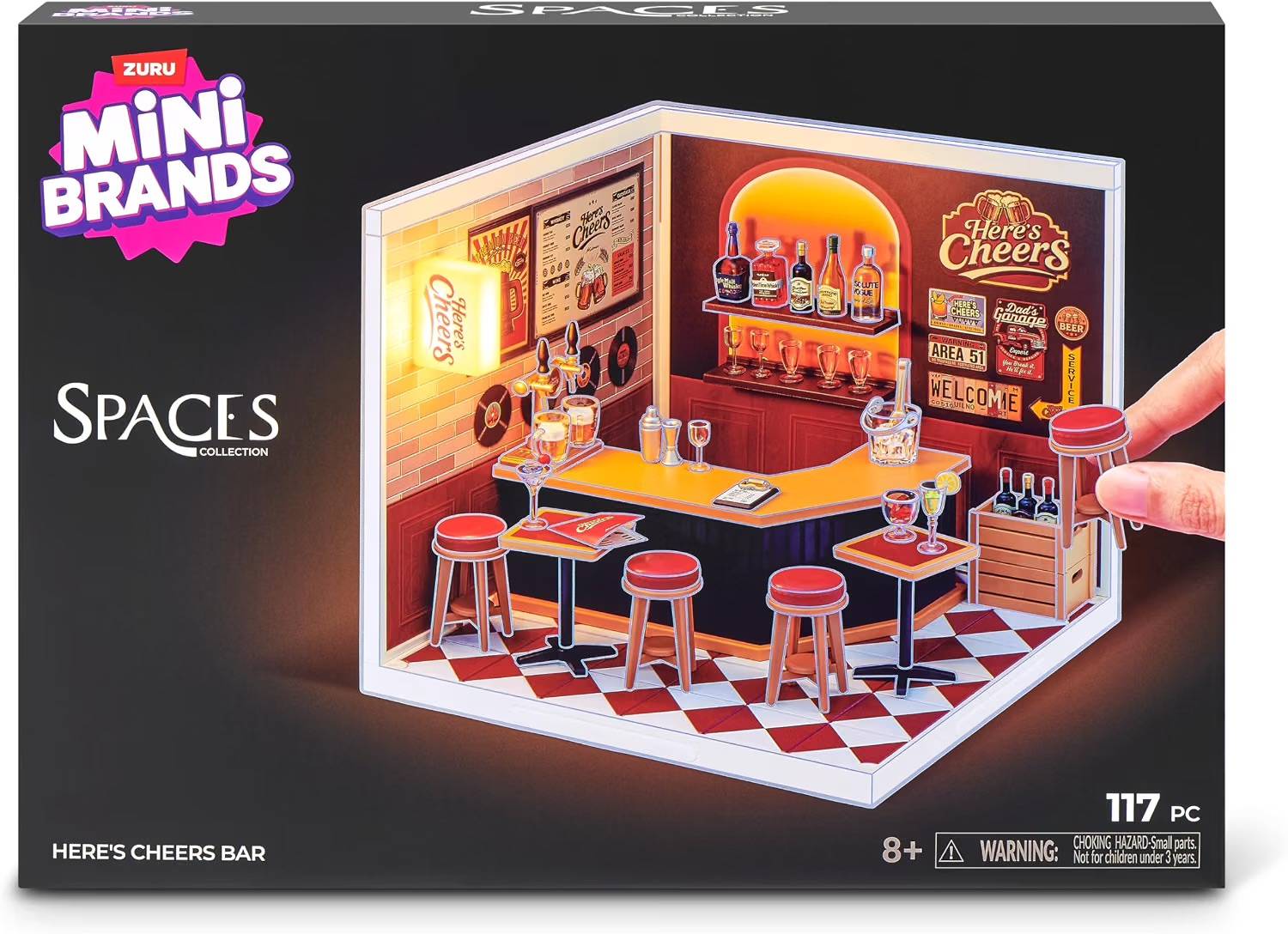 Schachteldesign für Zuru Mini Brands Spaces Collection „Here's Cheers Bar" Spielset, das eine Miniaturbar-Szene mit Barhockern, Regalen und Getränken zeigt; 117 Teile, ab 8 Jahren.