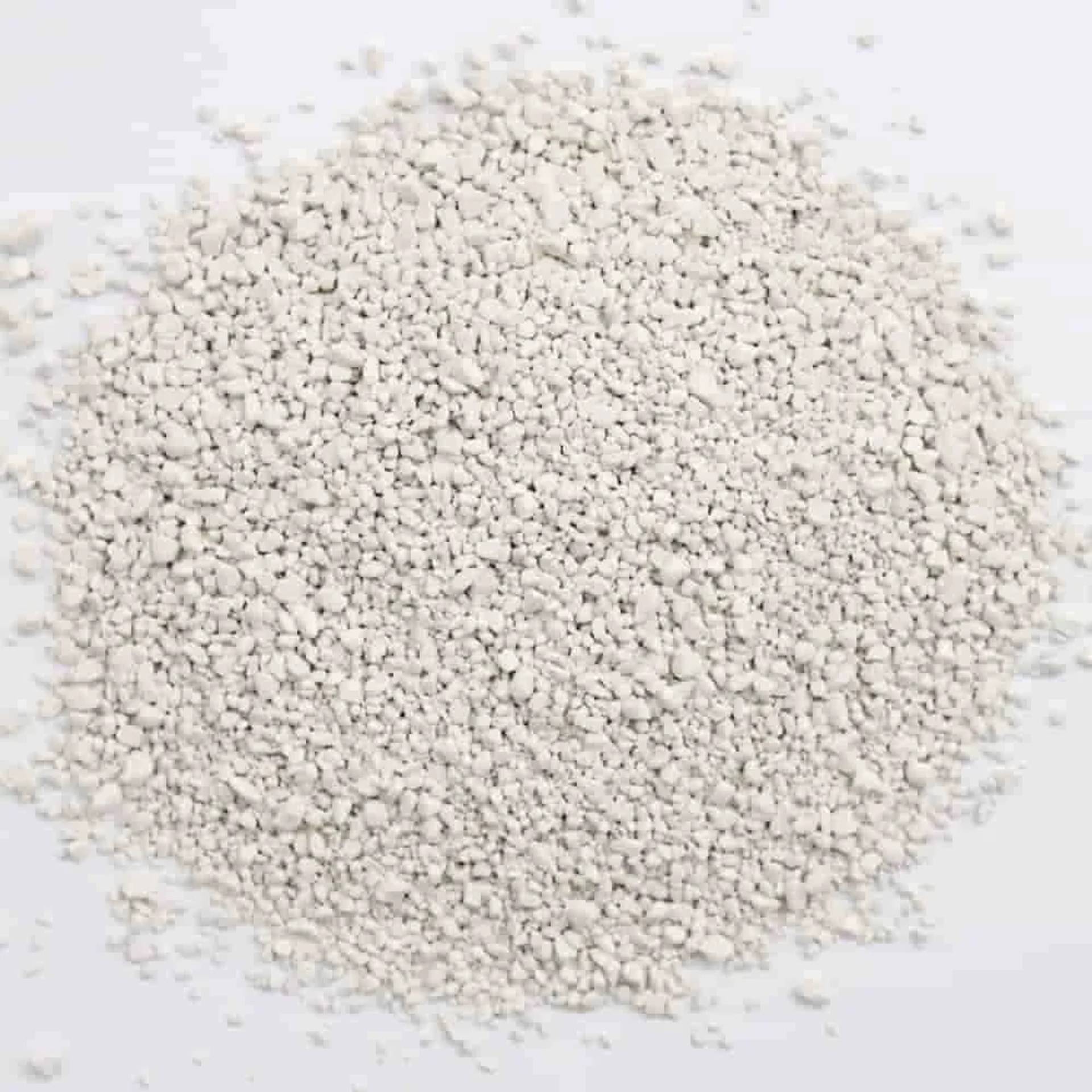 Ein Haufen kleiner weißer körniger Pellets auf einem schlichten weißen Hintergrund.