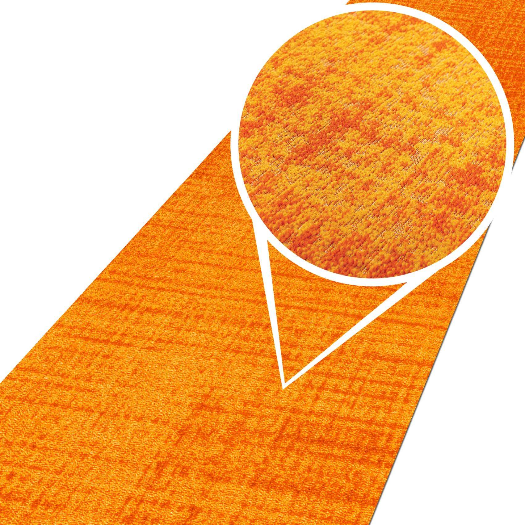 Orangefarbenes strukturiertes Stoff- oder Teppichmuster mit einer kreisförmigen vergrößerten Ausschnittsansicht, die die Oberflächenstruktur zeigt.