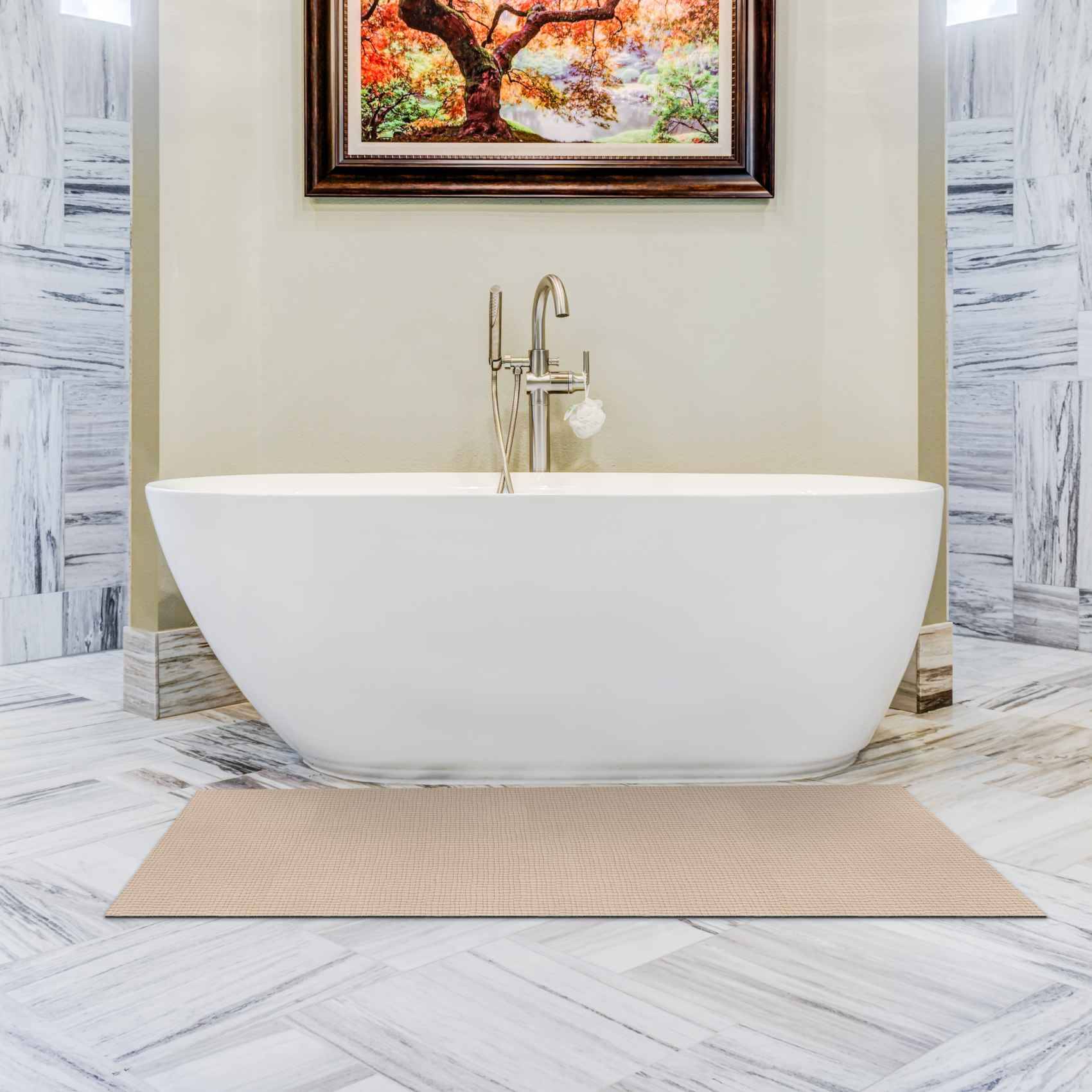 Modernes Badezimmer mit einer freistehenden weißen ovalen Badewanne, zentral unter gerahmter Wandkunst positioniert, auf Marmorboden mit einer beigen Badmatte.