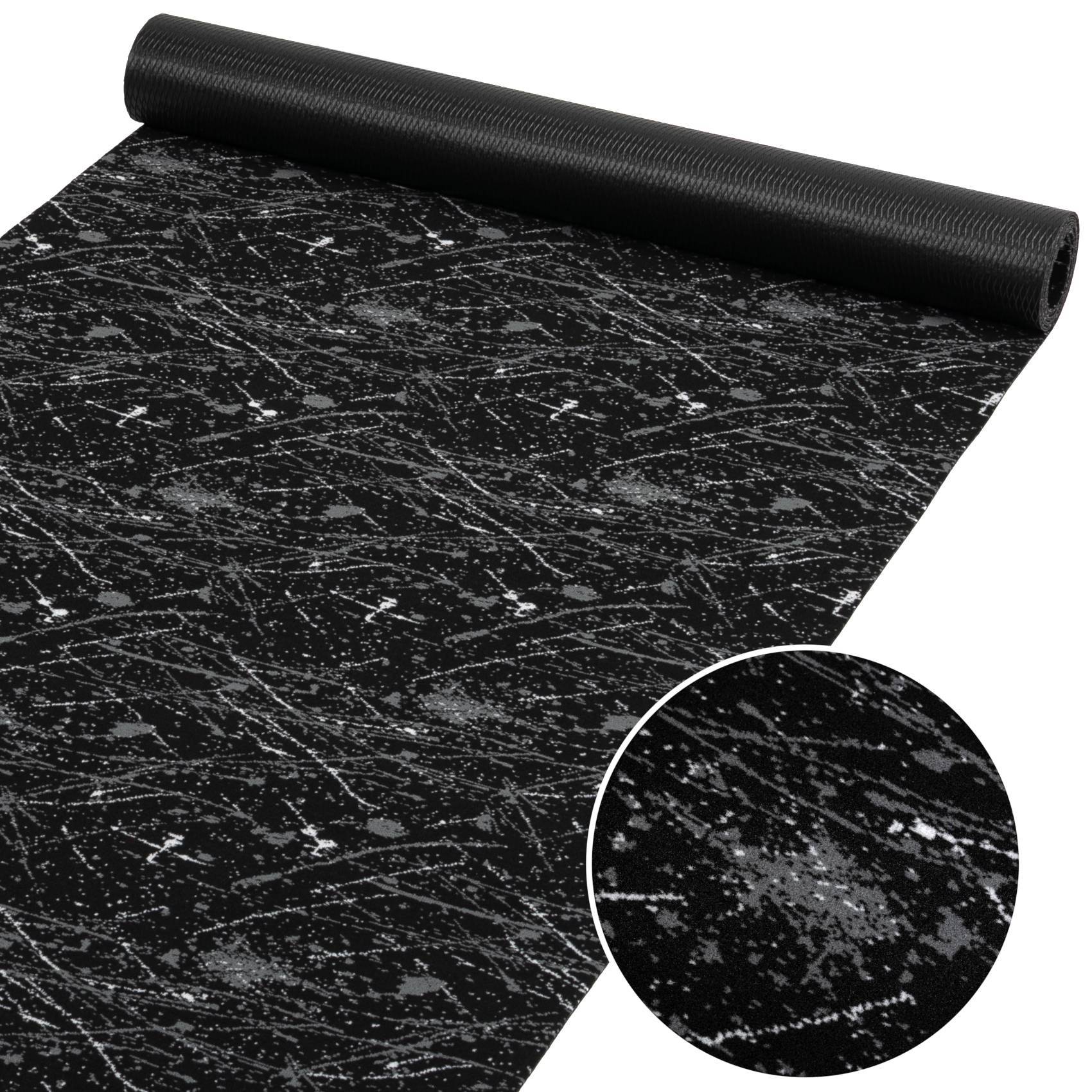 Schwarze gemusterte Yogamatte mit einer strukturierten, kratzerähnlichen Oberfläche, dargestellt ausgerollt mit einer kreisförmigen Detailaufnahme im Ausschnitt.