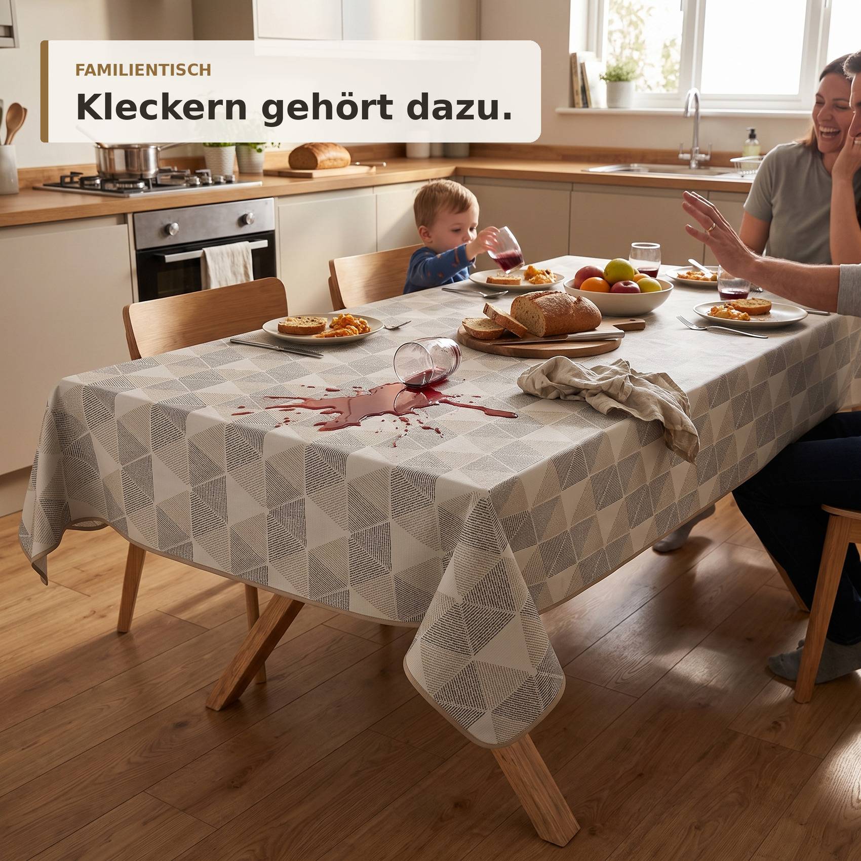 Ein Familie an einem Esstisch in einer hellen Küche, mit verschüttetem Saft und Unordnung; der Text lautet „FAMILIENTISCH Kleckern gehört dazu."