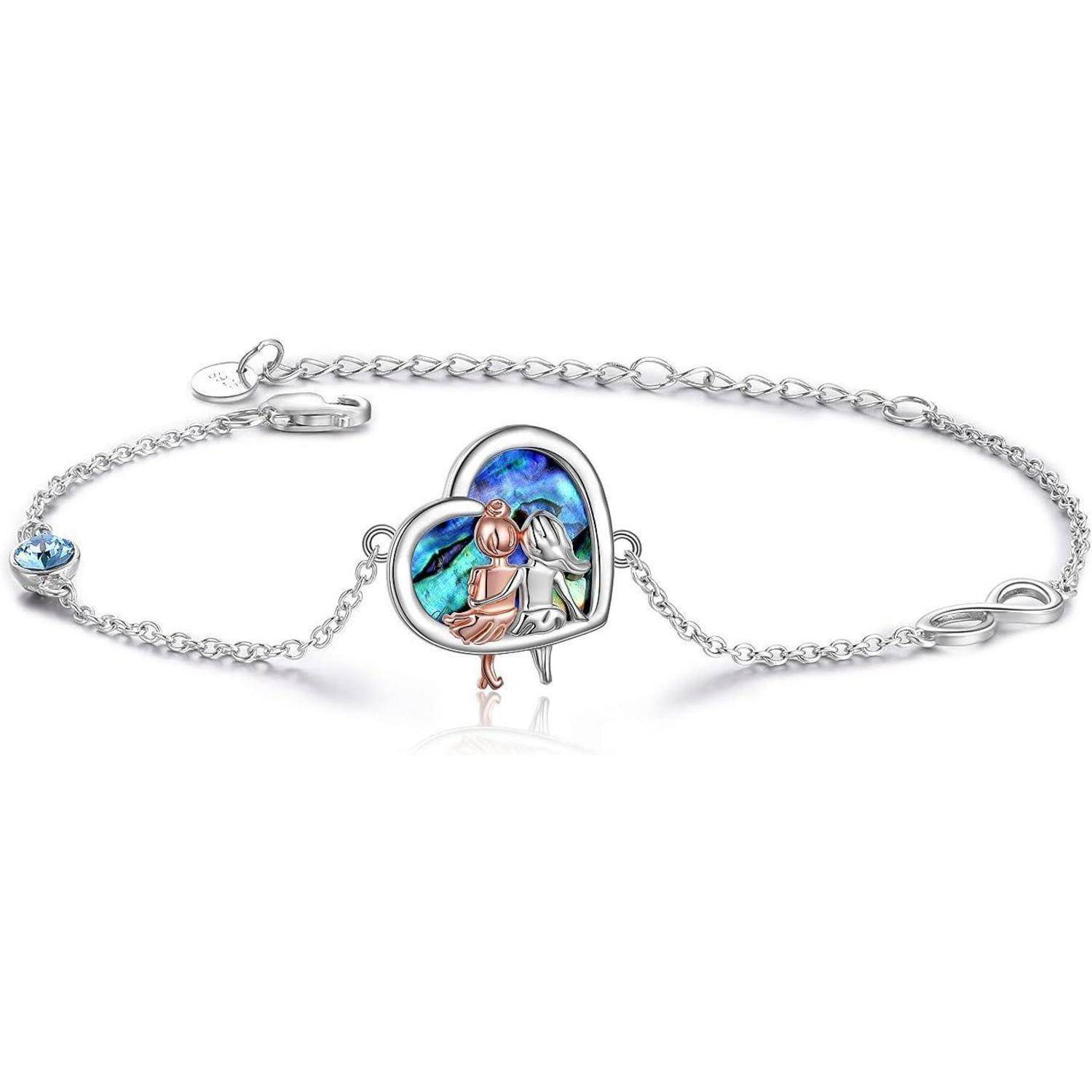 Silberarmband mit Herzanhänger und blauem Edelstein sowie zwei Figuren im Herzanhänger.