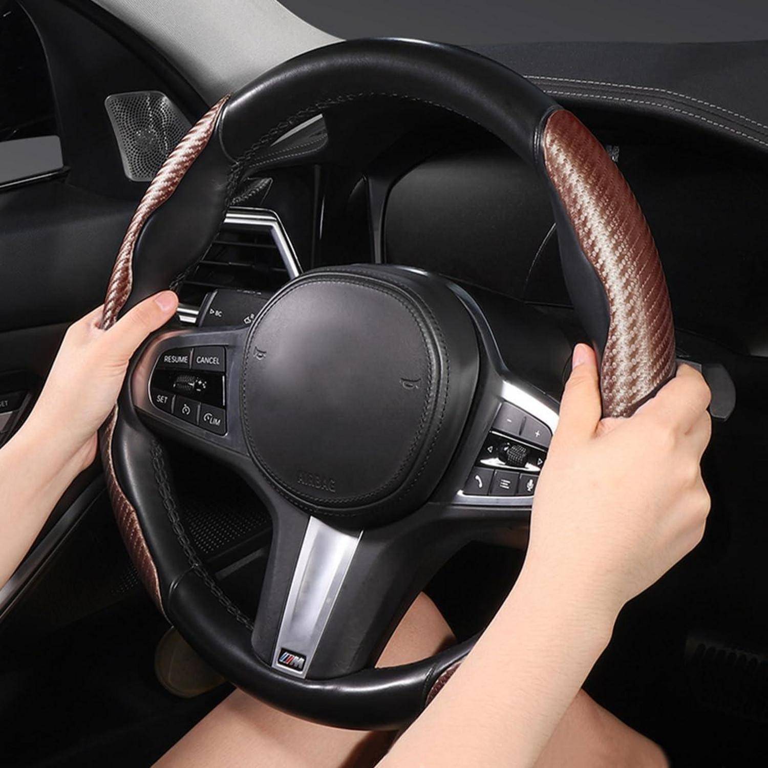 Hände, die ein mit Leder bezogenes Lenkrad eines Autos greifen, mit integrierten Steuertasten sichtbar im Fahrzeuginnenraum.