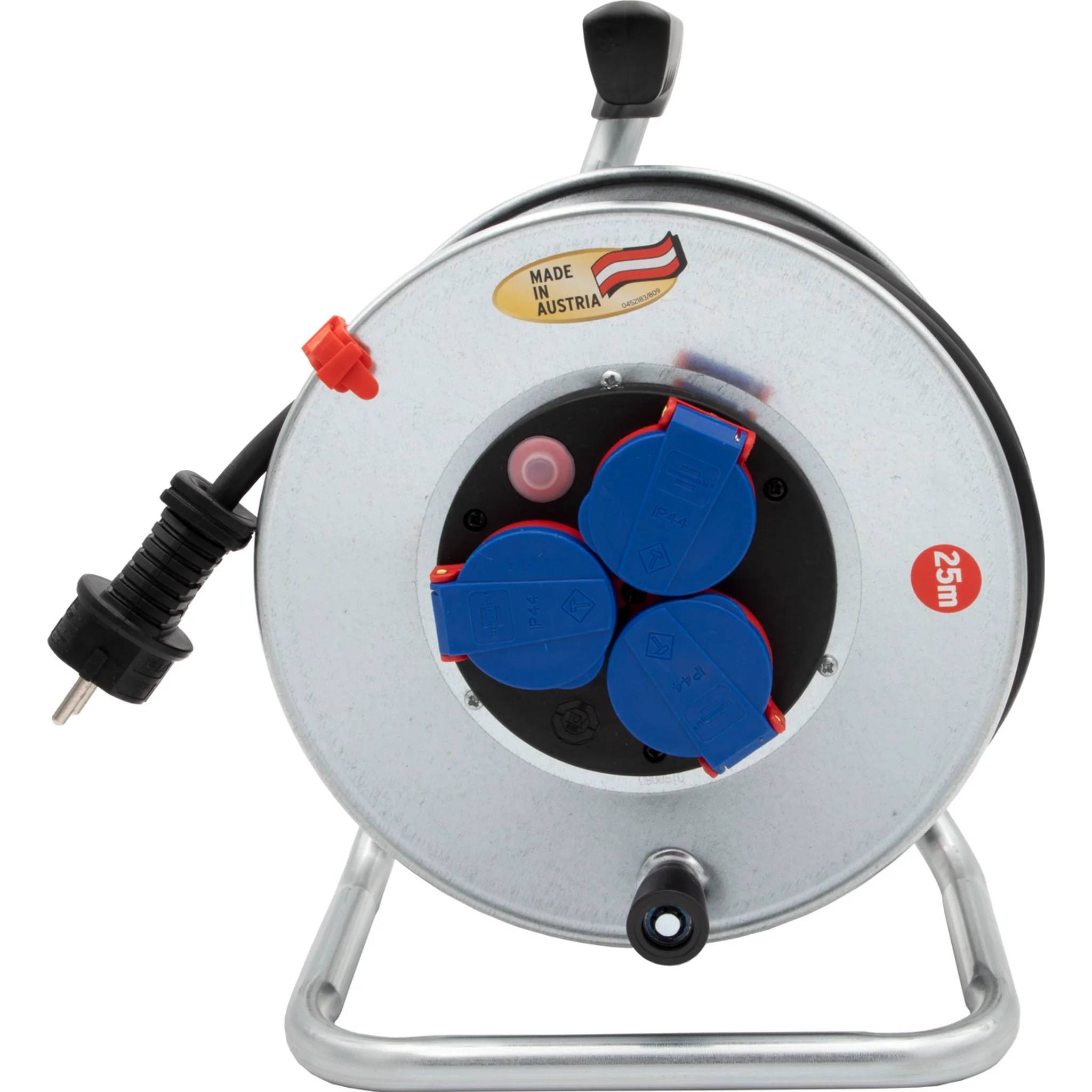 Metallkabelrolle mit Griff und Ständer, die drei blaue Steckdosen und einen schwarzen Stecker zeigt; Etikett „Made in Austria" und Markierung „25m"".