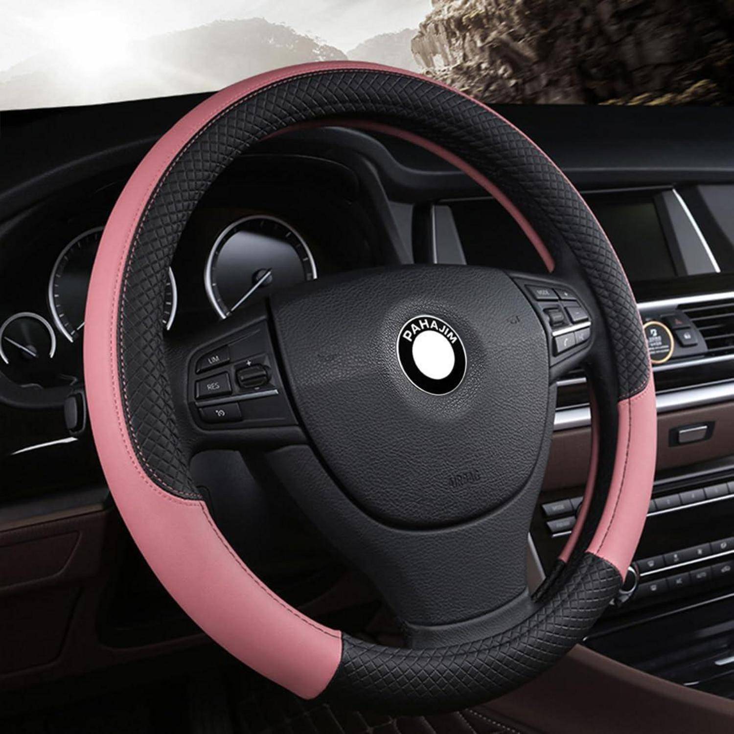 Rosa-schwarze Lenkradabdeckung auf einem Auto-Lenkrad, eingebaut in einem Fahrzeugarmaturenbrett.