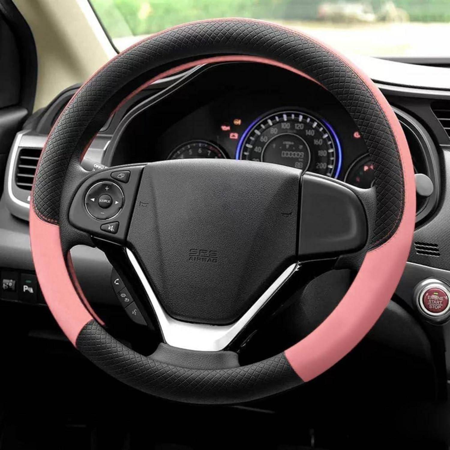 Lenkrad eines Autos mit einer rosa und schwarzen Lederbezug, gezeigt im Inneren eines Fahrzeugs mit dem Armaturenbrett und den Instrumenten dahinter.
