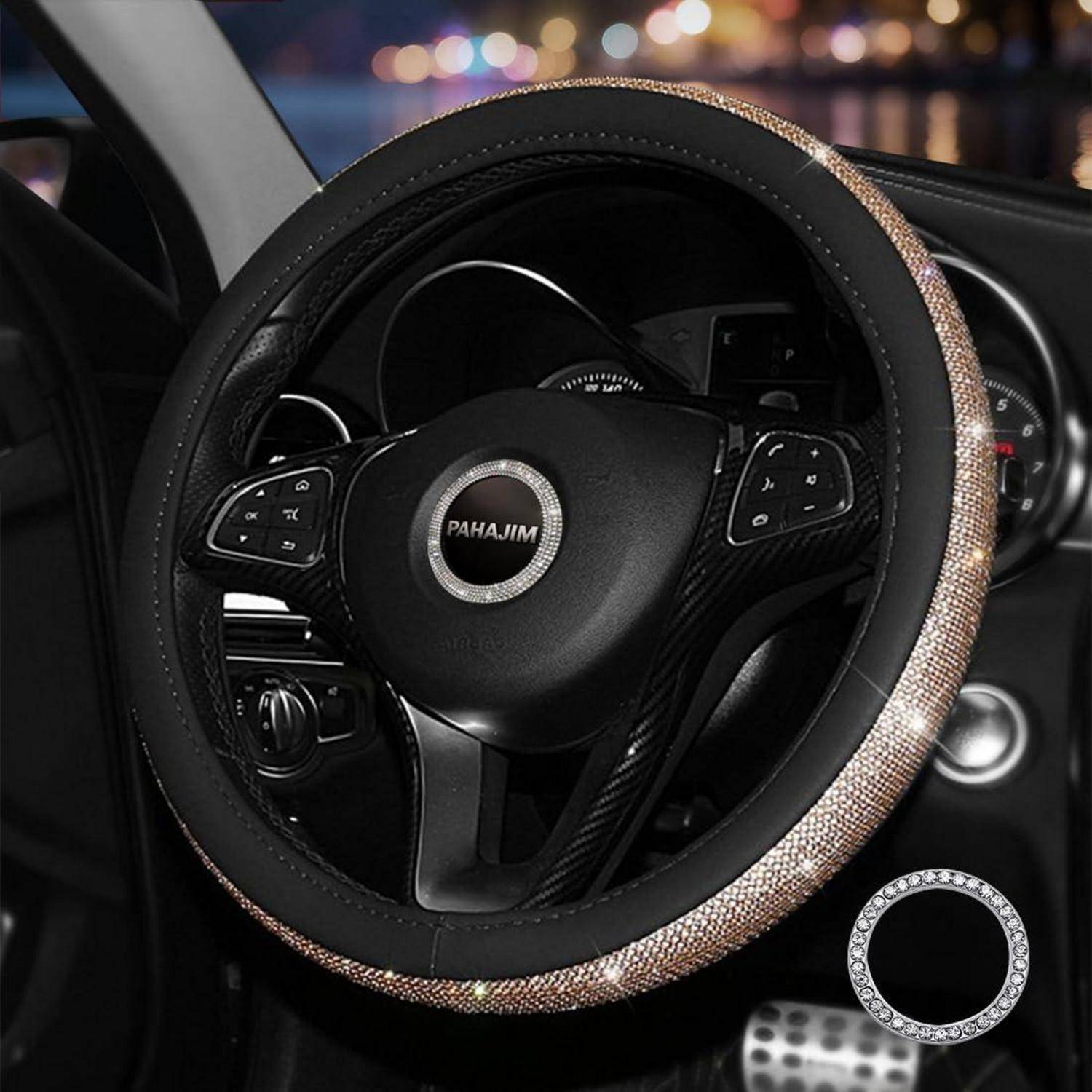 Nahaufnahme eines Autolenkrads mit glitzernder Zierauflage und Bedienelementen, gezeigt im Fahrzeuginneren bei Nacht.