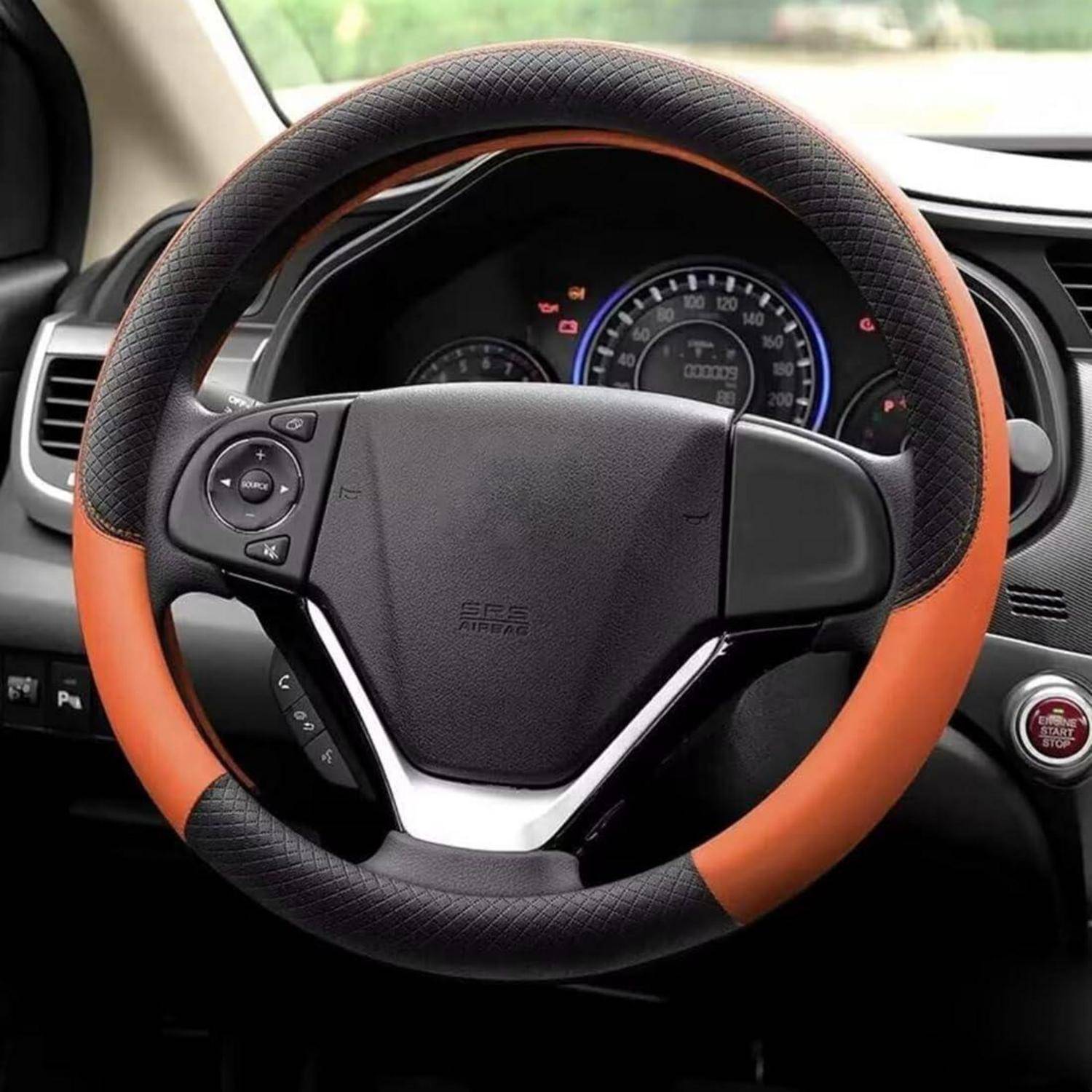 Nahaufnahme einer schwarzen und orangefarbenen Lenkradbezug mit integrierten Kontrolltasten in einem Auto, aufgenommen vom Fahrersitz aus.