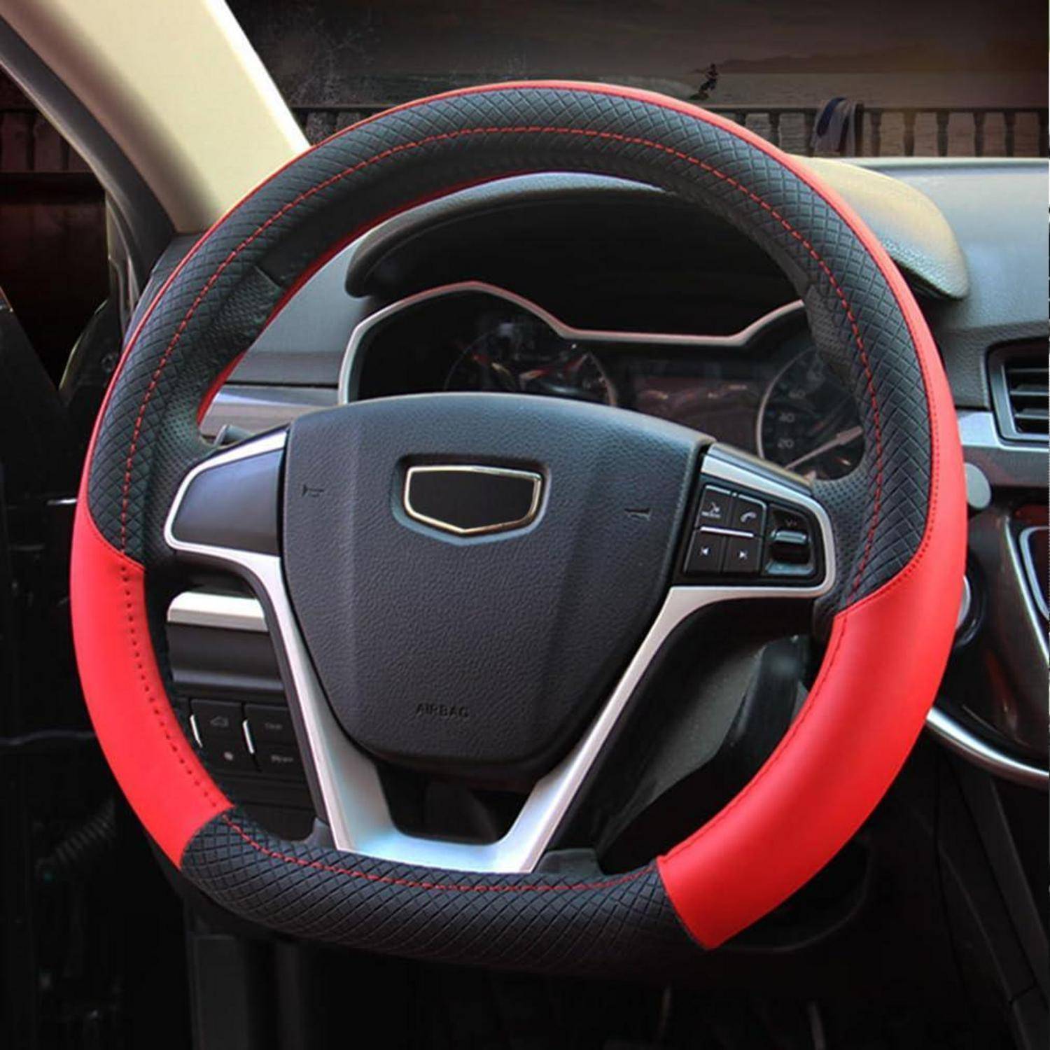 Nahaufnahme eines Autolenkrads mit einer rot-schwarzen Abdeckung und integrierten Steuertasten im Armaturenbrett-Innenraum.