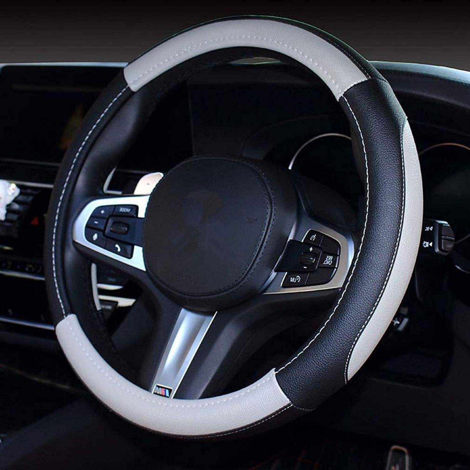 Nahaufnahme eines schwarzen BMW-Lenkrads mit integrierten Bedientasten im Inneren eines Autos.
