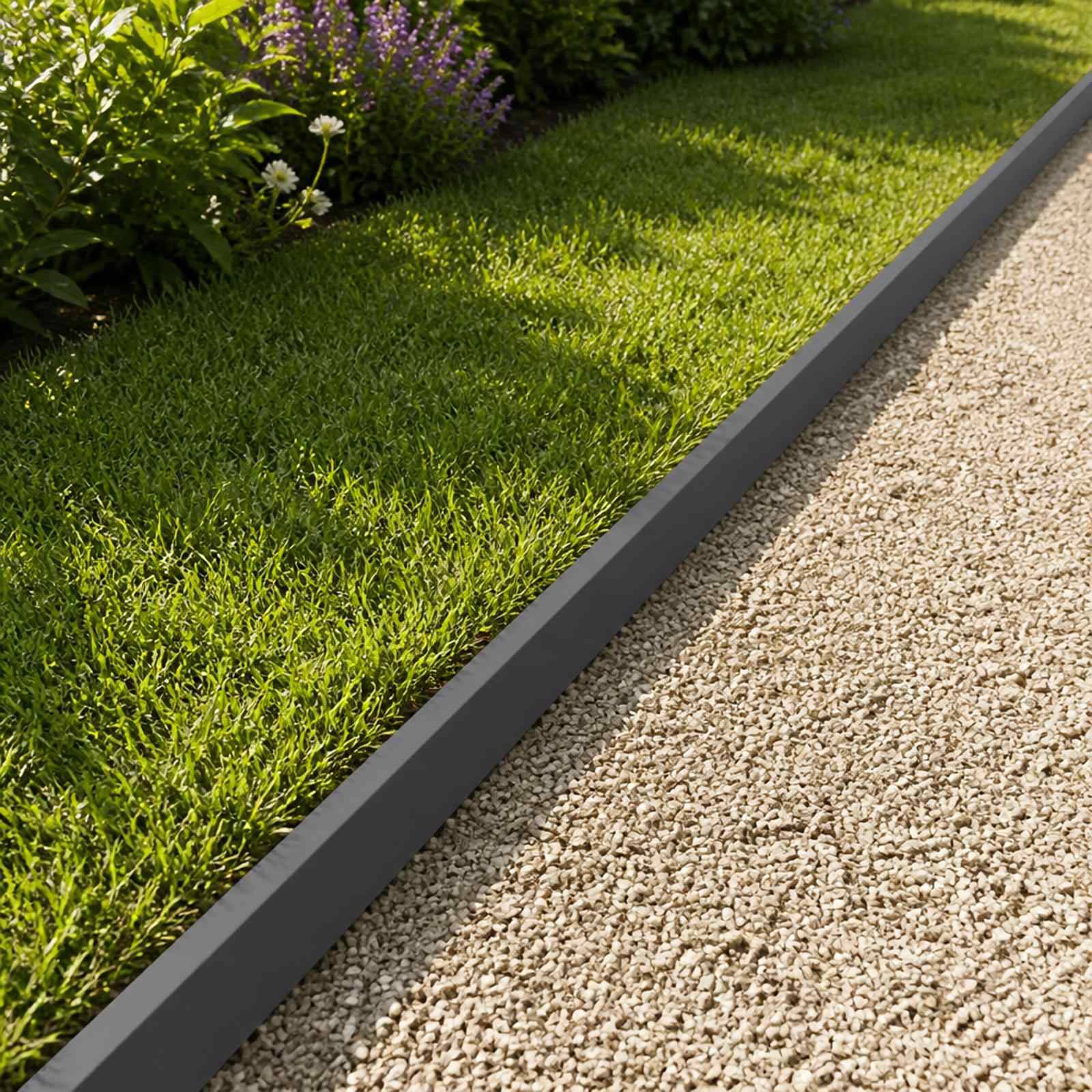Diagonale Nahaufnahme einer gestalteten Gartenrabatte, mit grünem Gras und Pflanzen, die durch einen dunklen Kantenstein von einem Kiesweg getrennt sind.