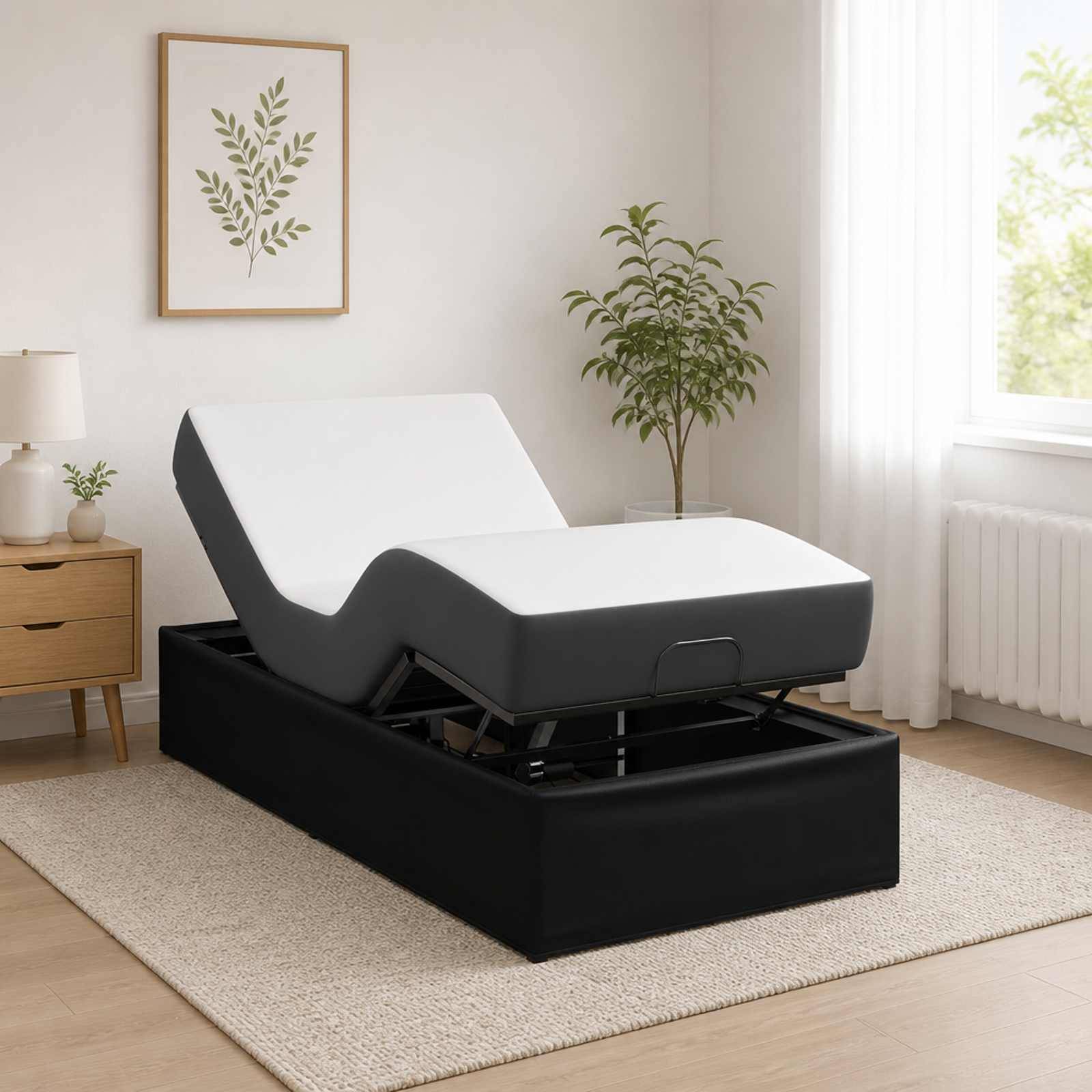 Verstellbares schwarz-weißes Liegebett mit erhöhter Rückenlehne in einem hellen Schlafzimmer, dargestellt auf einem Teppich neben einem Nachttisch und Fenster.