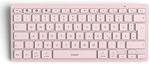 Rosa kompakte kabellose Tastatur mit weißen Tasten und einer langen Leertaste, auf einem einfachen, hellen Hintergrund dargestellt.