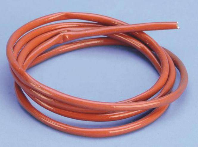 Aufgerolltes orange isoliertes Elektrokabel oder Stromkabel auf hellblauem Hintergrund.