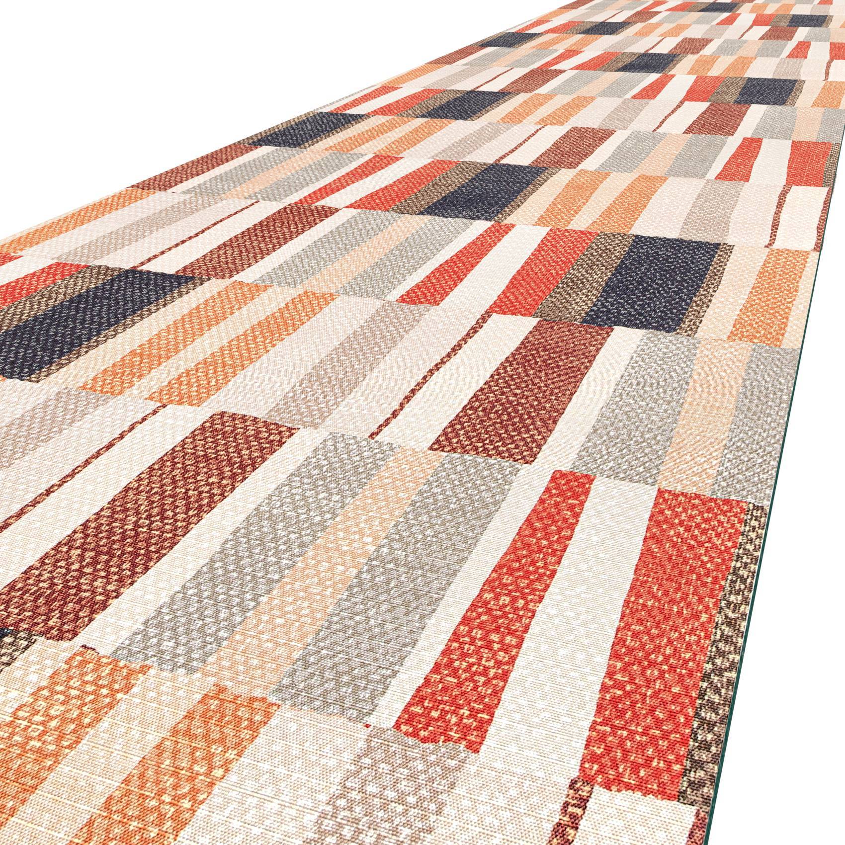 Ein langer rechteckiger Patchwork-Teppich mit mehrfarbigen gewebten Stoffstreifen in Rot-, Beige-, Grau-, Orange- und Blautönen.