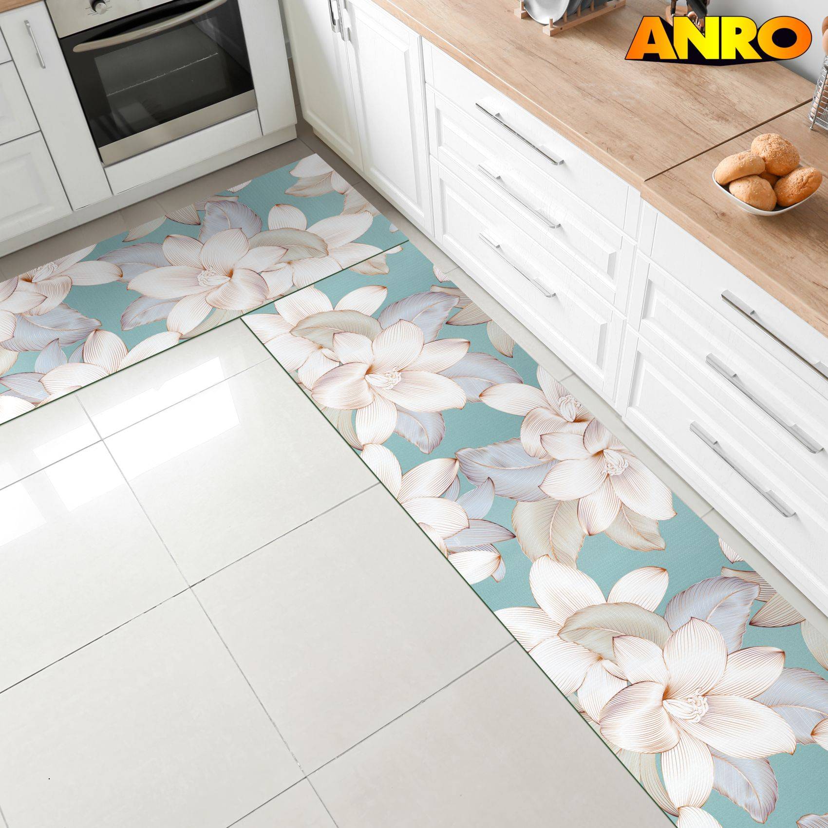 Küchenmatte mit großem weißem Blumenmuster auf teelblauem Hintergrund neben weißen Schränken und einem Herd, mit der Marke „ANRO" in der Ecke.