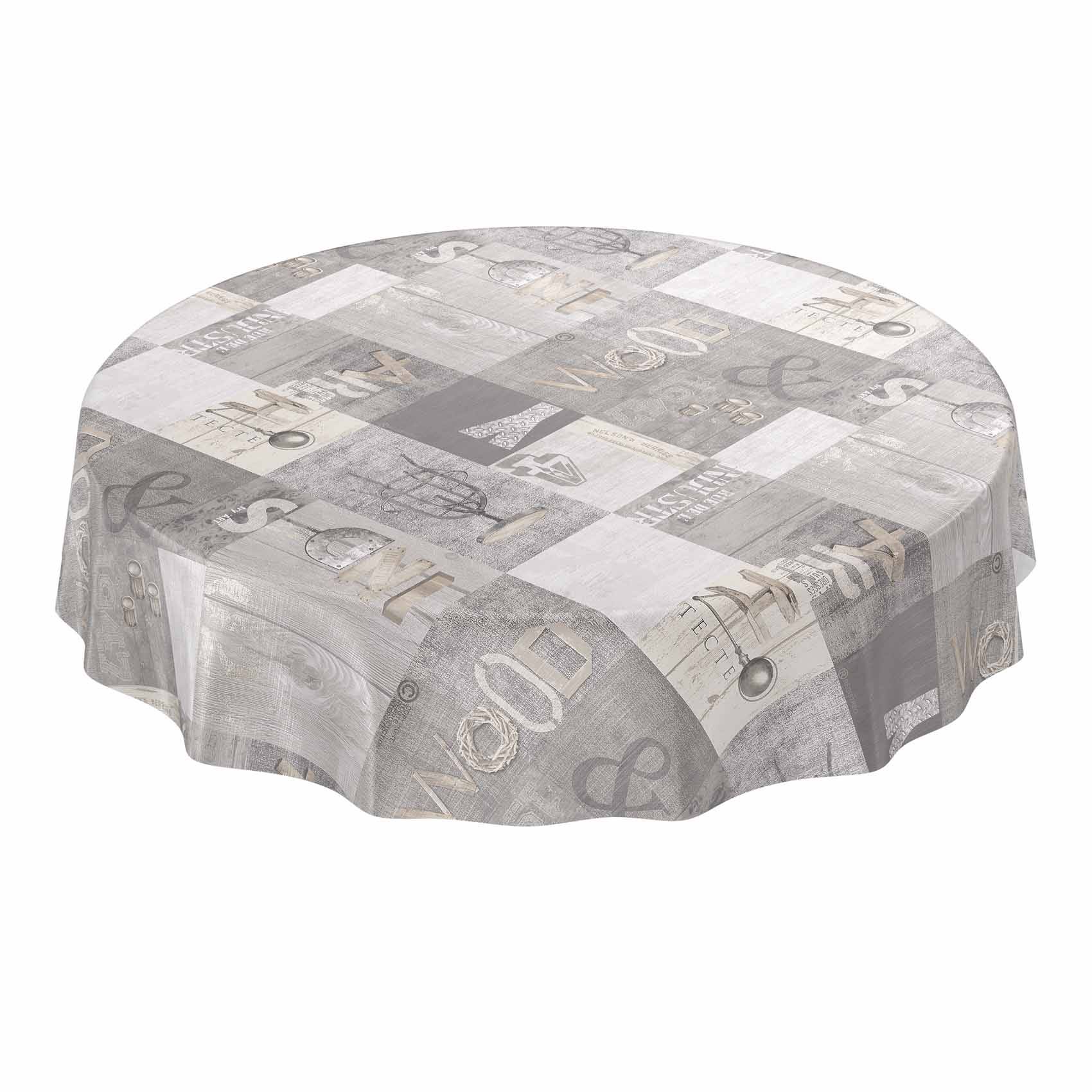 Runder Tisch mit grauer Patchwork-Tischdecke mit Buchstaben, Zahlen und Drucken im Vintage-Stil.