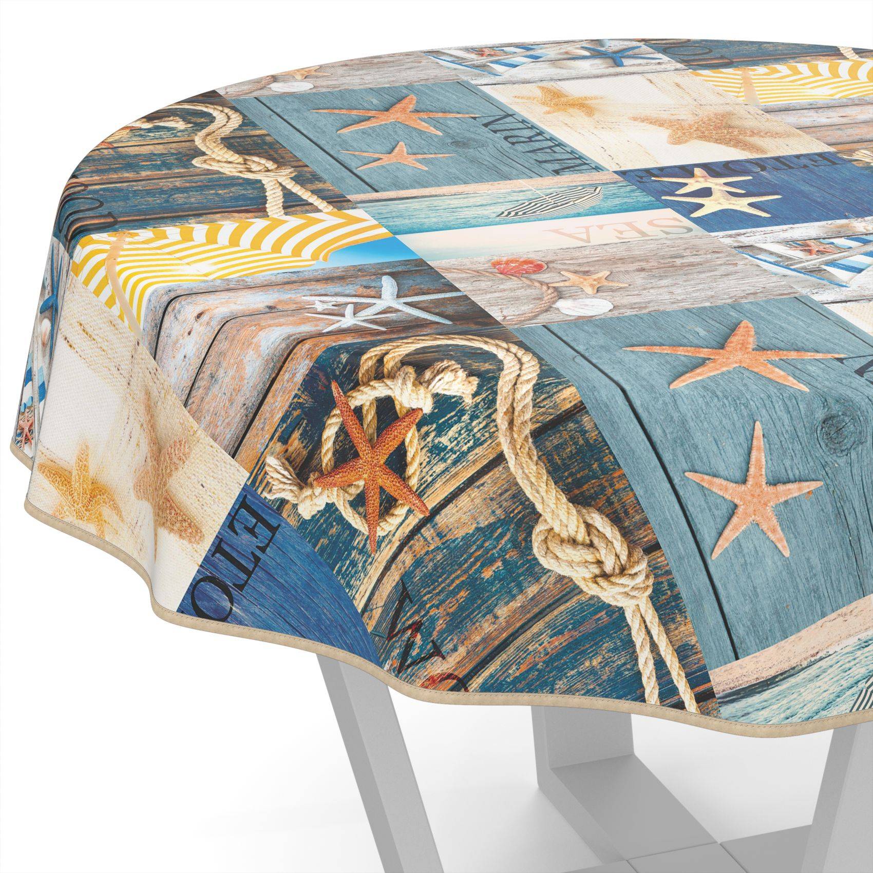 Runder Tisch mit einer Küsten-Patchwork-Tischdecke, die Seesterne, Seil, Holzbretter und blaue Strandmuster aufweist.