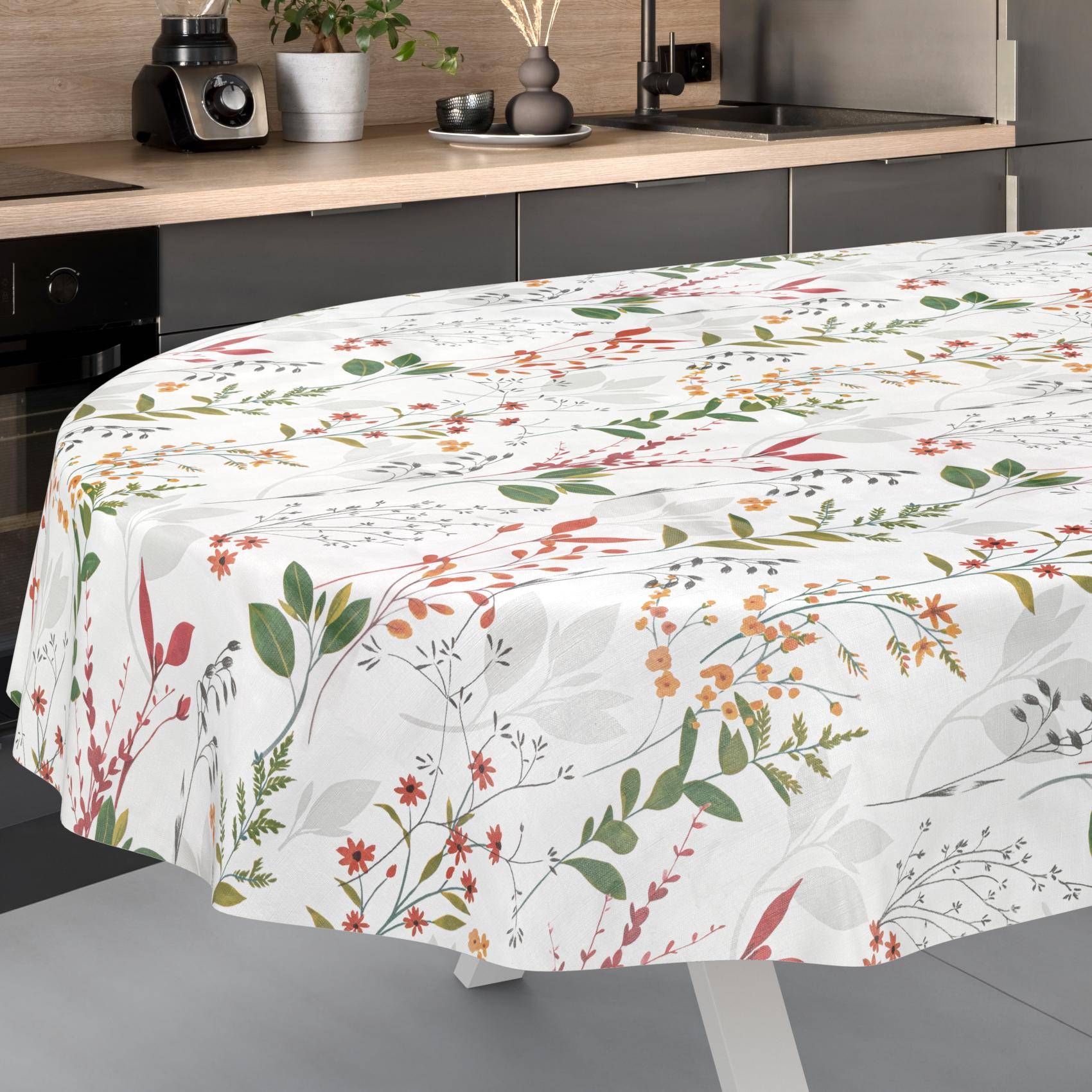 Runder Esstisch mit einer weißen Tischdecke mit Blumenmuster in einer modernen Küche.