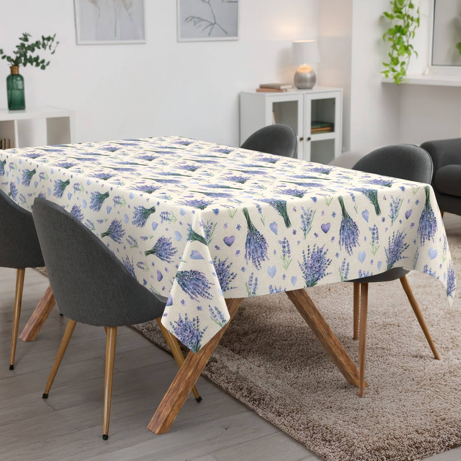Esstisch mit einer lavendelgemusterten Tischdecke, umgeben von dunkel gepolsterten Stühlen in einem hellen, modernen Wohn-Esszimmer.