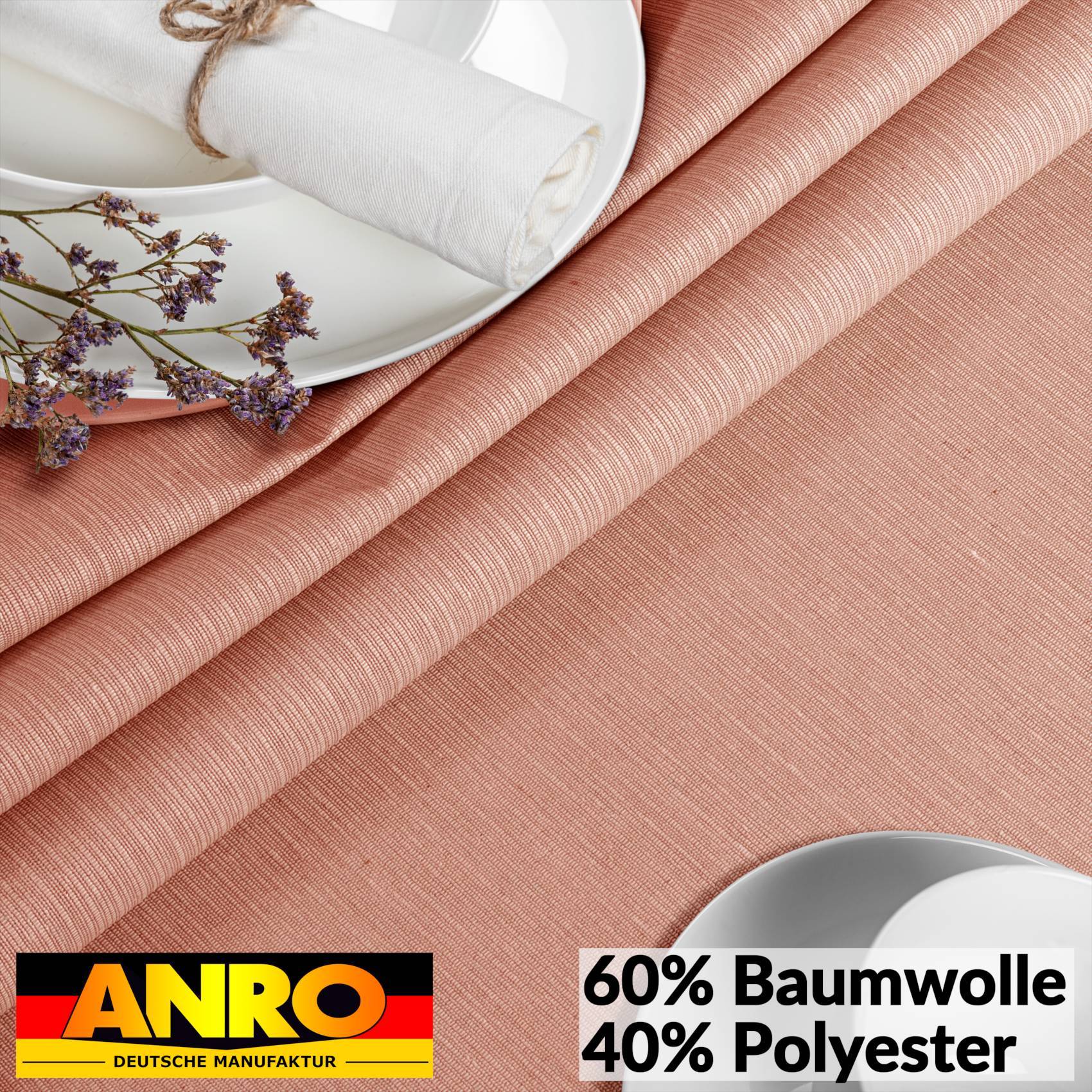 Pfirsichfarbener strukturierter Stoff mit einem Teller, aufgerolltem weißem Tuch und getrockneten Blüten; das Etikett zeigt „60% Baumwolle 40% Polyester